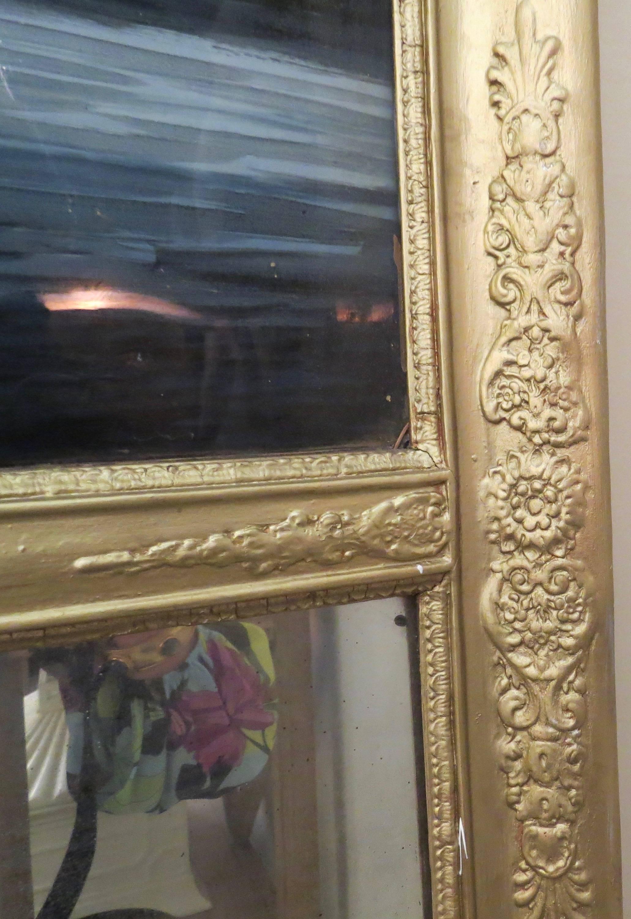 This trumeau has a hunt scene image, reverse painted on glass. The gold frame moulding has been painted over. The mirror is original. It is French from the early 19th century.