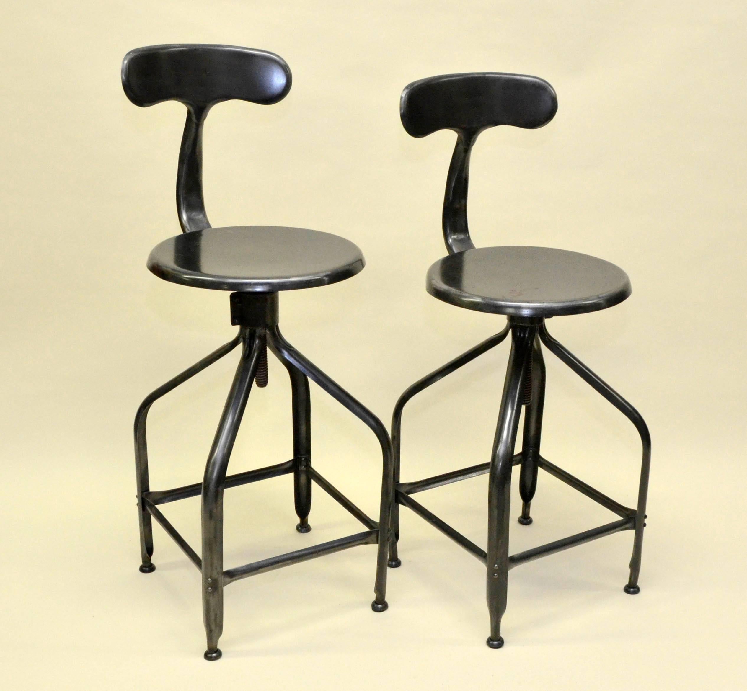 Pair of French adjustable high stools with whale tail backrest produced in the 1960s by Nicolle. Polished iron finish. 

Height seat adjustable from 64 to 75 cm available.

In stock two pairs of two stools (4 stools in total). 

Collector's