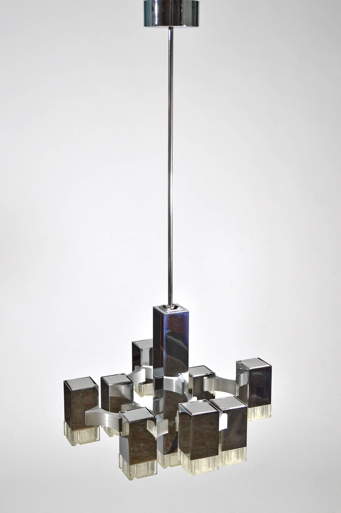 An iconic piece of Italian design from 1970s, the Cubic chandelier, designed by Gaetano Sciolari for his company based in Rome, circa 1970.
It's modular structure is composed by chromed metal parallelepipeds with Lucite diffusers, held together by