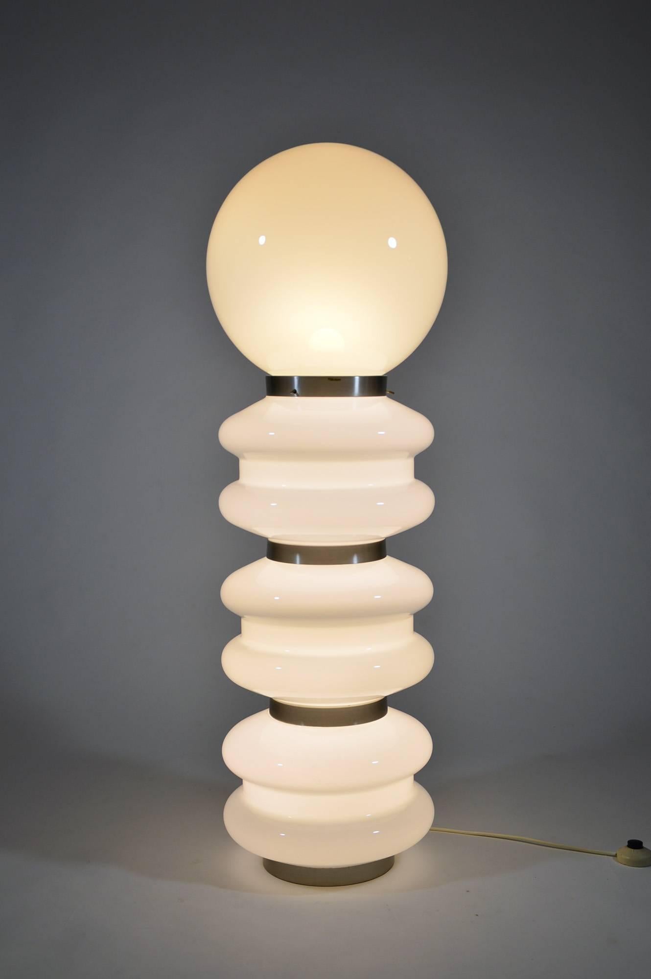 This highly decorative floor lamp has been produced by Stilux Milano in 1960s and is made of opaline glass, with brushed aluminium details.
It has six lights in the body, with E14 screw socket and one in the upper globe, with E27 socket. It can be