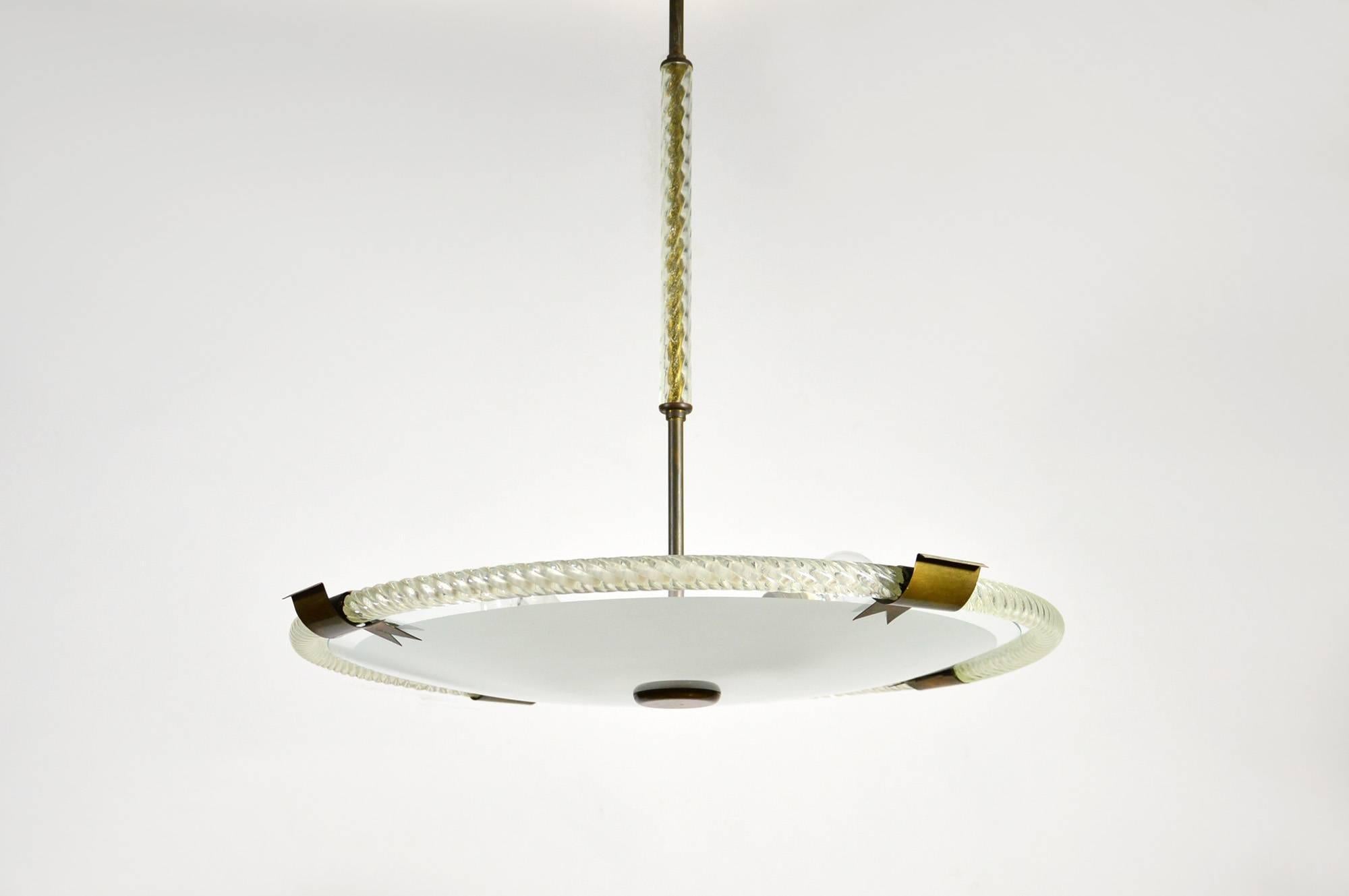 A Murano glass pendant with brass fittings. It features a sandblasted glass disc surrounded by a 