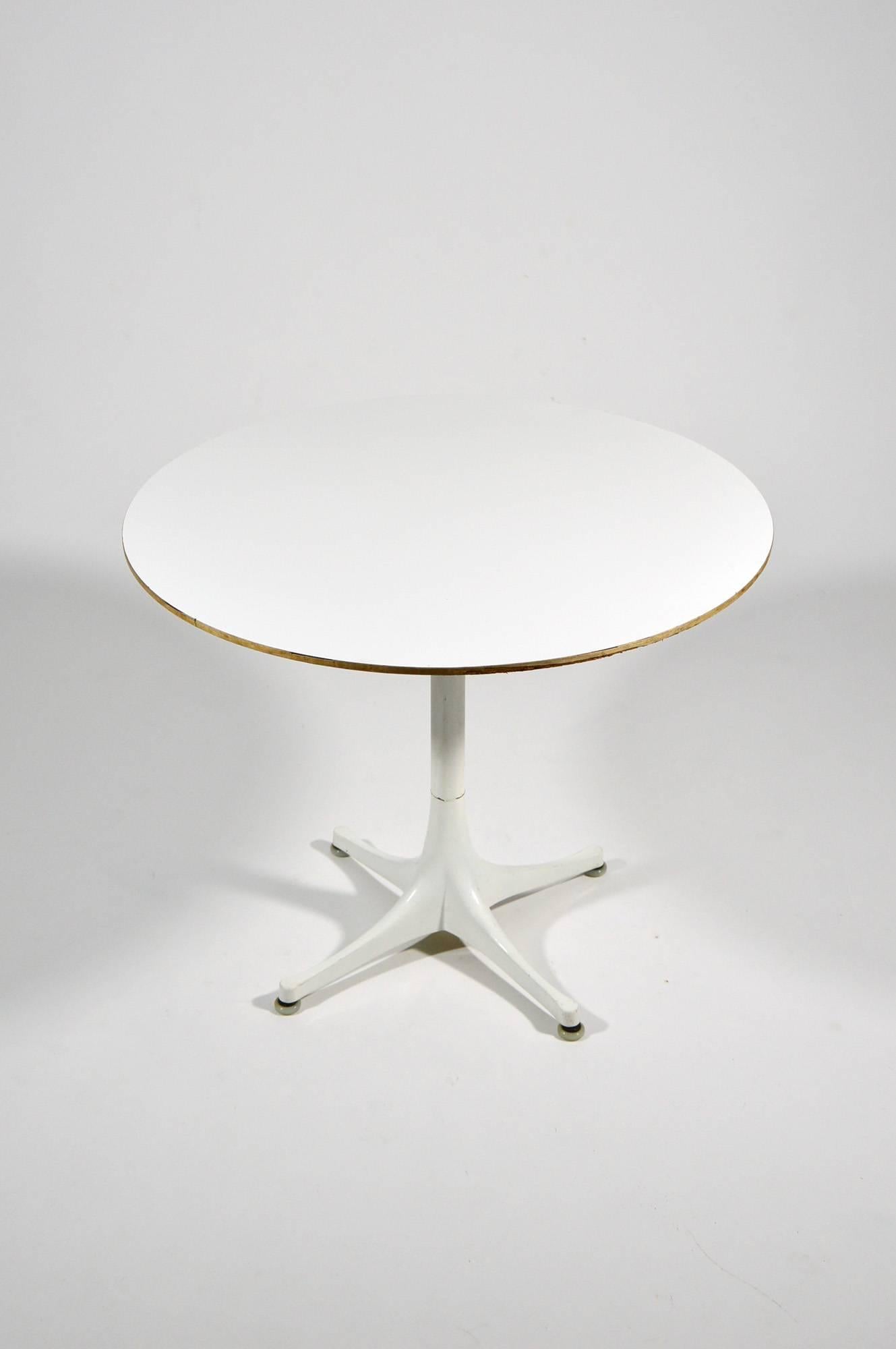 Pedestal table, designed by George Nelson for Herman Miller in 1954, with lacquered aluminium base and white laminate chipboard top.
In overall good condition and signed, the chipboard has some defects.