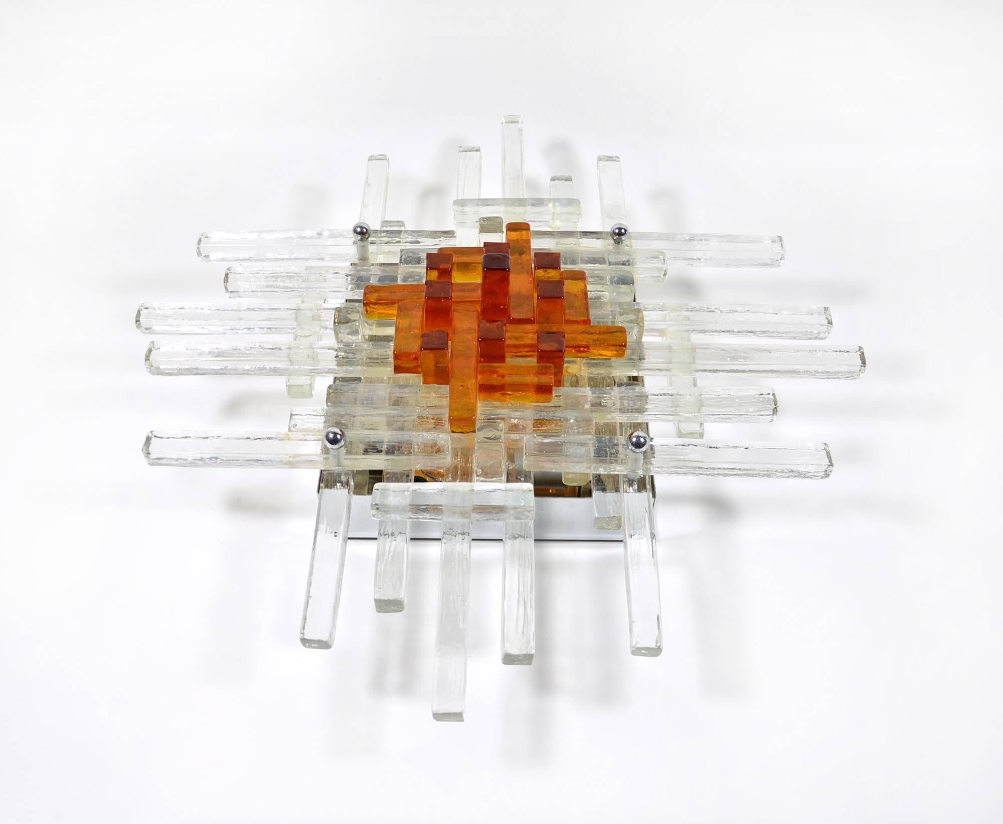 This lamp, made of amber and transparent glass with a chromed metal structure, was designed in 1970s by Albano Poli for his firm Poliarte, based in Verona, Italy.
It can be mounted on a wall or a ceiling and carries 4 incandescent or led bulbs with