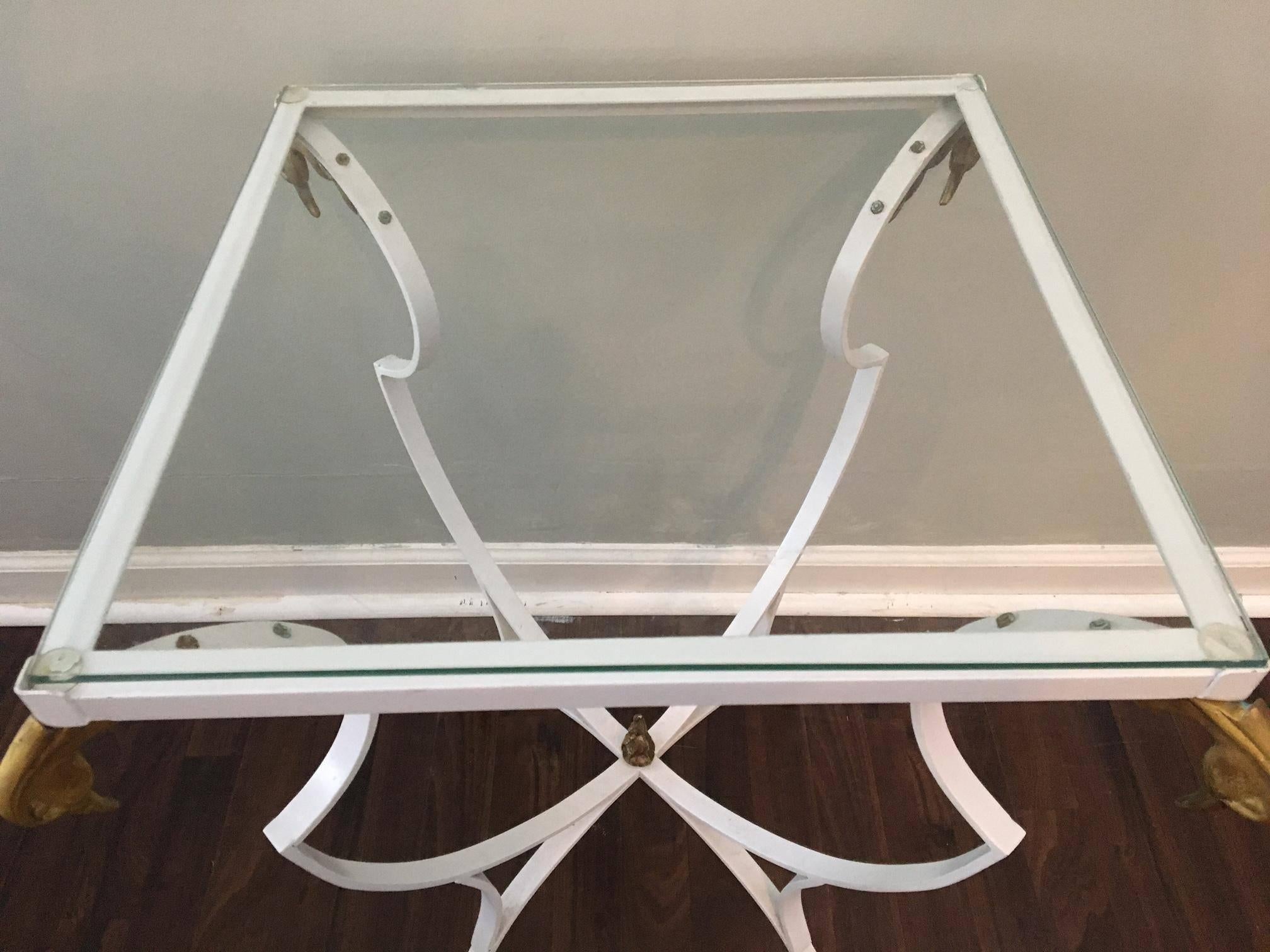 White wrought iron side table features brass swan heads and brass claw feet. By Samuel Copelon (unsigned).  Excellent vintage condition. Small imperfections in paint and one very small chip on underside of glass edge (see photo). 