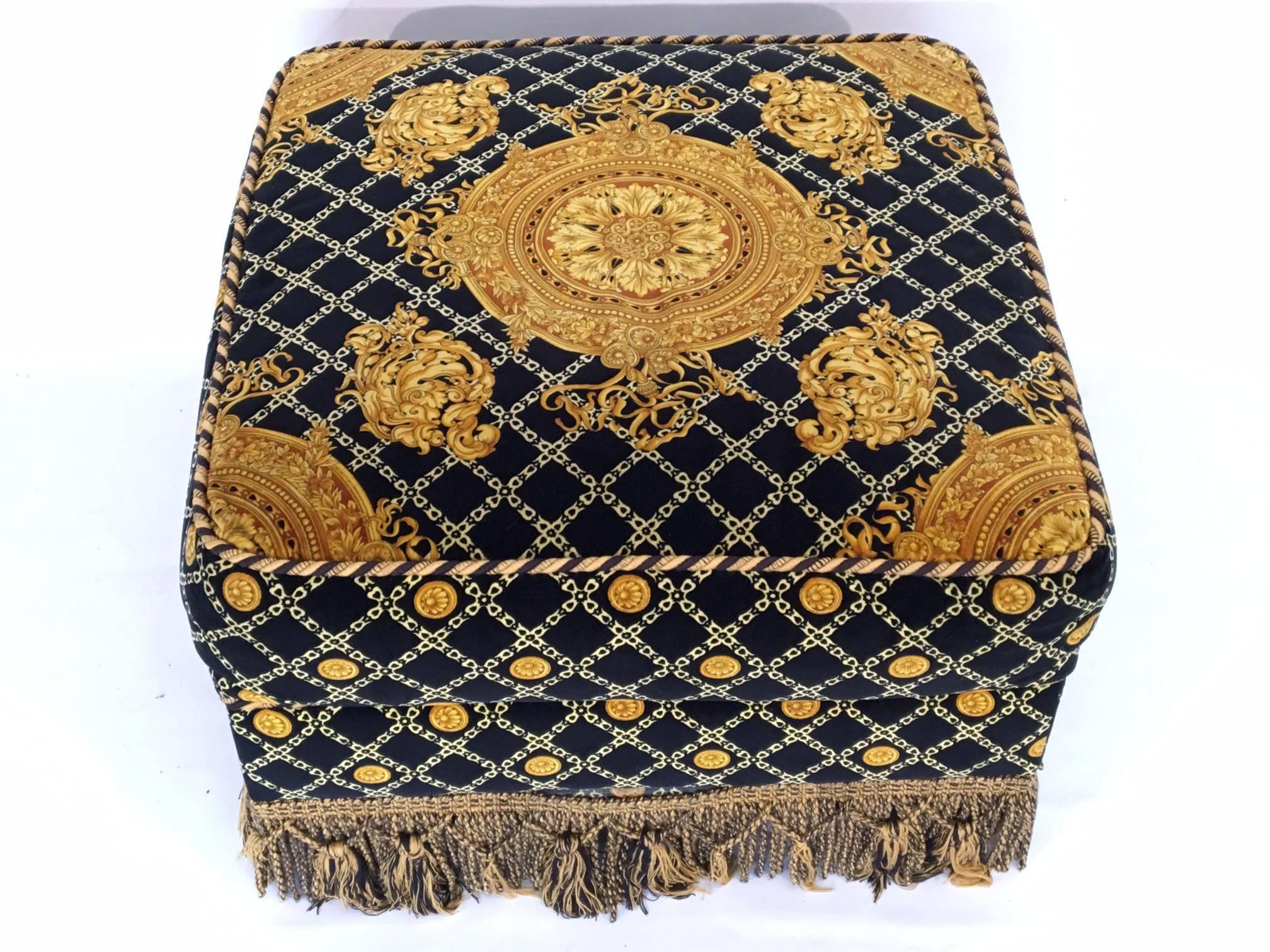 Plush upholstered ottoman by Stefano Giovanni (Jiovanni) of Italy. Upholstered in a Versace style print. Excellent vintage condition other than trim which has some missing tassels. Matching pair of sofas and coffee table also available.