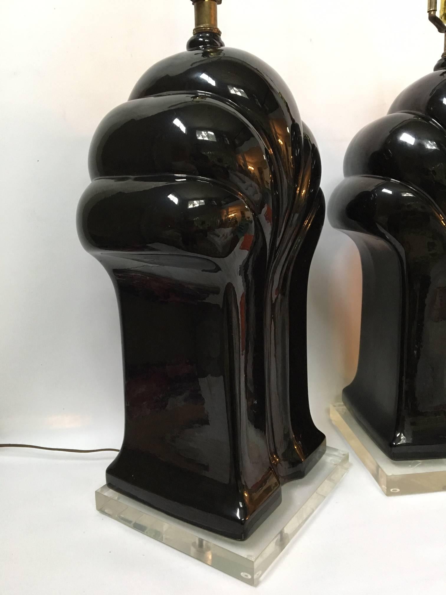 Pair of large sculptural black table lamps in an iconic art deco form. The ceramic body sits on a Lucite plinth base.
Each lamp measures 9