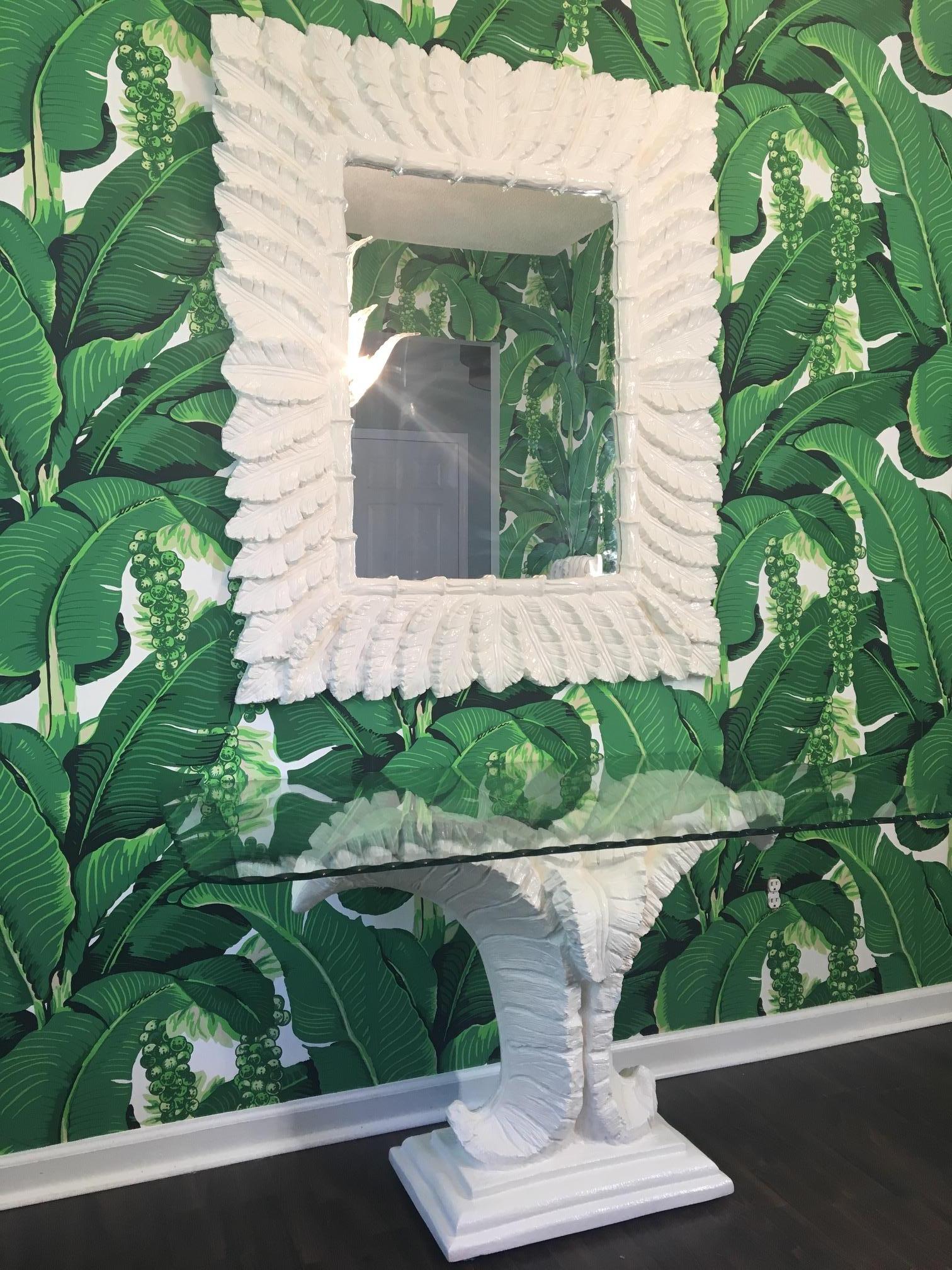 Console table sculpted in the form of large palm leaves with matching mirror. Based on the style of Serge Roche or Dorothy Draper. Console features dramatic tropical palm tree designed pedestal with scalloped edge glass top. Newly lacquered gloss