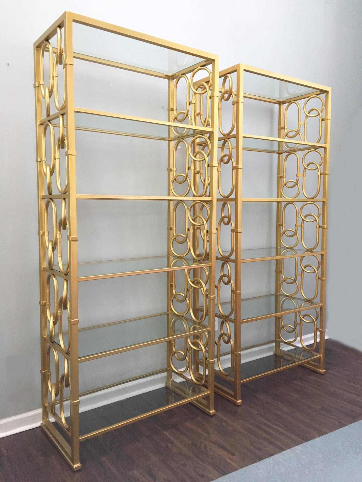 Monumental Hollywood Regency etagere pair features large gold chain link detailing and 6 glass shelves each. In pristine condition. Each stands over 7 feet tall.