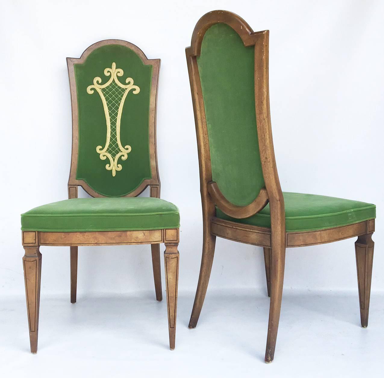 Exquisite custom set of eight dining chairs inspired by Dorothy Draper. Each chair sits atop neoclassic tapered legs.
Green velvet cushioned seat and backrest with an ornate golden embroidered detail.
Six dining chairs and two armchairs. Excellent