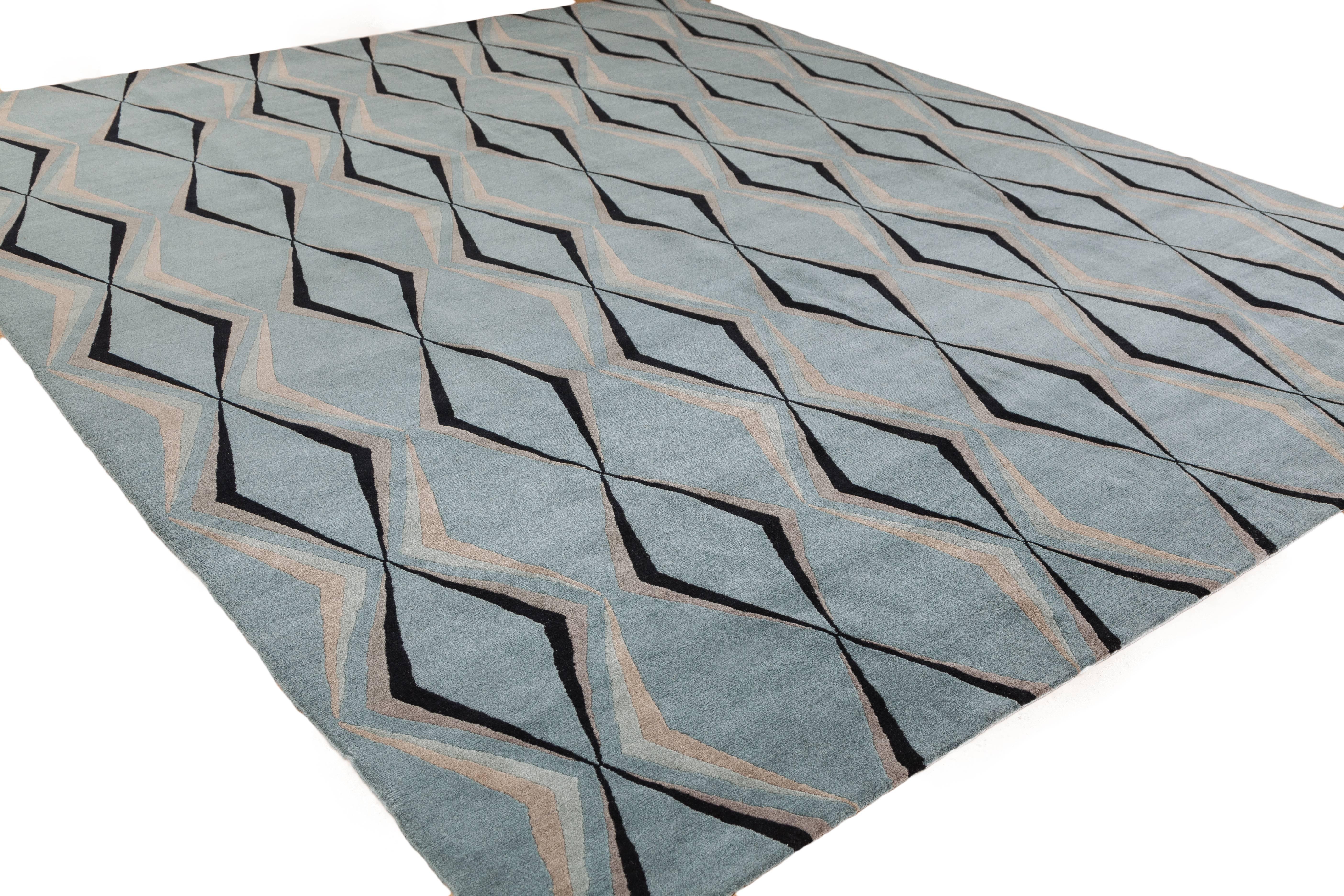 Art moderne with an optical twist. This nouveau design is woven using 100% Tibetan wool and features hues of mineral, slate blue, taupe, grey and ebony. This piece has been crafted by hand in our true 100 knot quality.