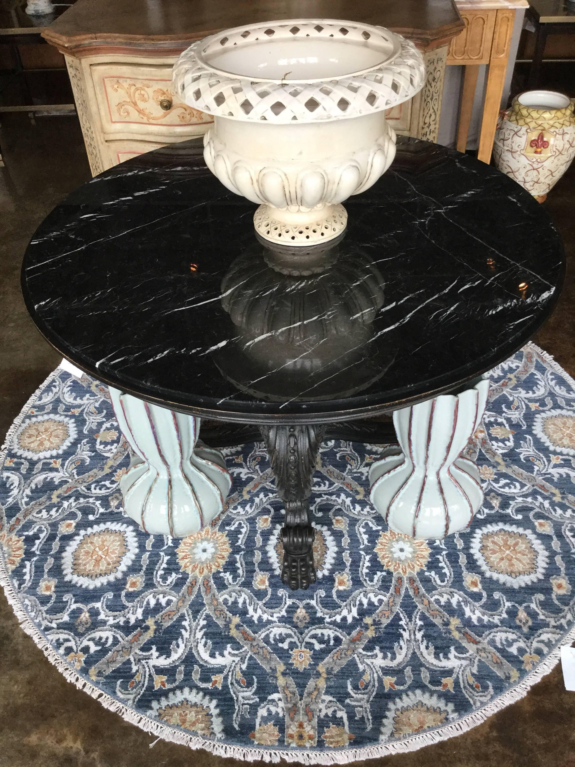 Round Empire style table with marble top on an intricately hand-carved base in antique black finish, Italy.