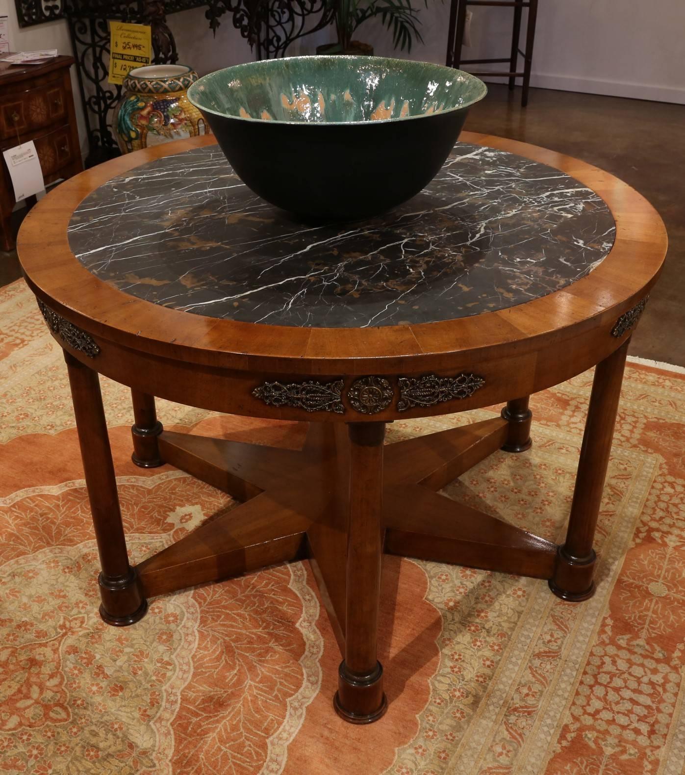 One-of-a-Kind walnut center table based on 19th Century original design with honed brown/black marble inset, antiqued brass accents and six legs featuring a starburst base.