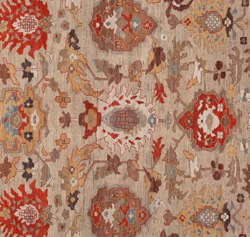 Handwoven recreation of antique Persian Sultanabad rug. The field is taupe with an allover pattern and geometric motifs in blue, brown, red, and green. The border is taupe with palmettes and vines. Handwoven in Iran.
 