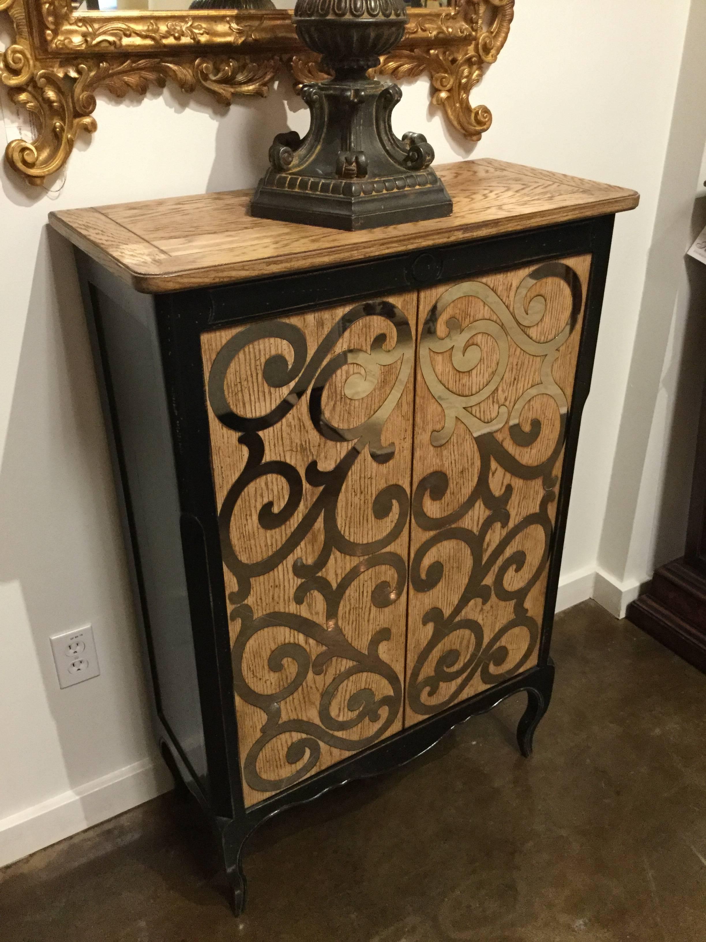 Hand-painted two-door chest in a distressed ebony finish with ivory decorations featuring a latticework and floral design.  Created by the artisans of Italy.