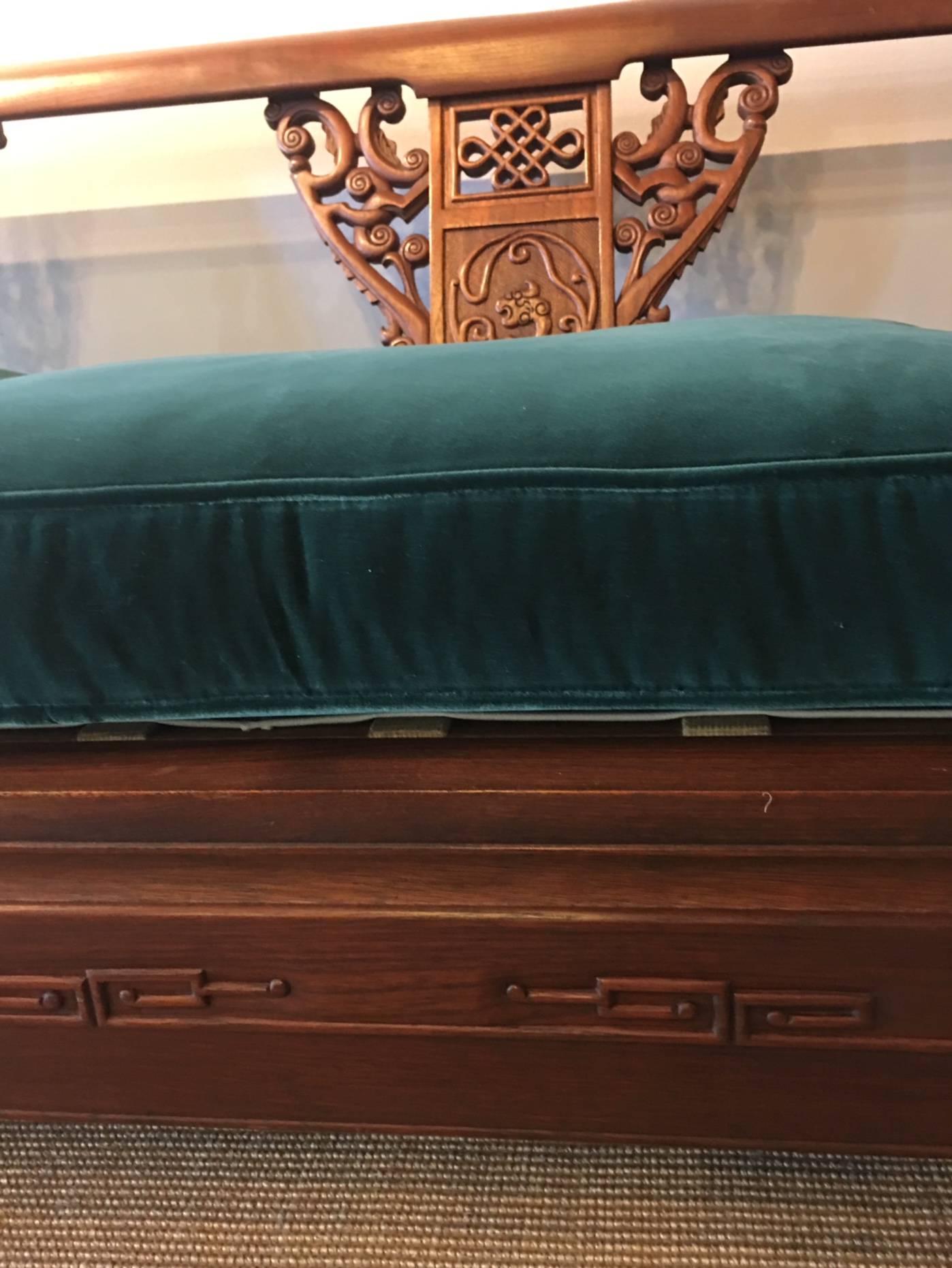 This carved wooden sofa is spectacular and in excellent condition. Three-seat cushions, ming feet, curved arms, carving on the base, this is a unique and lovely sofa. Beneath the cushions is a lift-up folding platform. The frame is in excellent