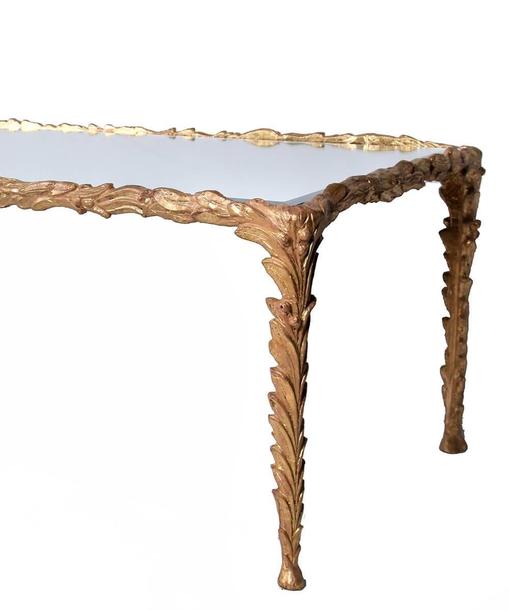 A beautifully detailed iron base with an applied gold finish and a beveled mirror top make this cocktail table a showstopper without being too visually intrusive. Elegant, organic, textured, and reflective. Traditional with a twist, and sturdy