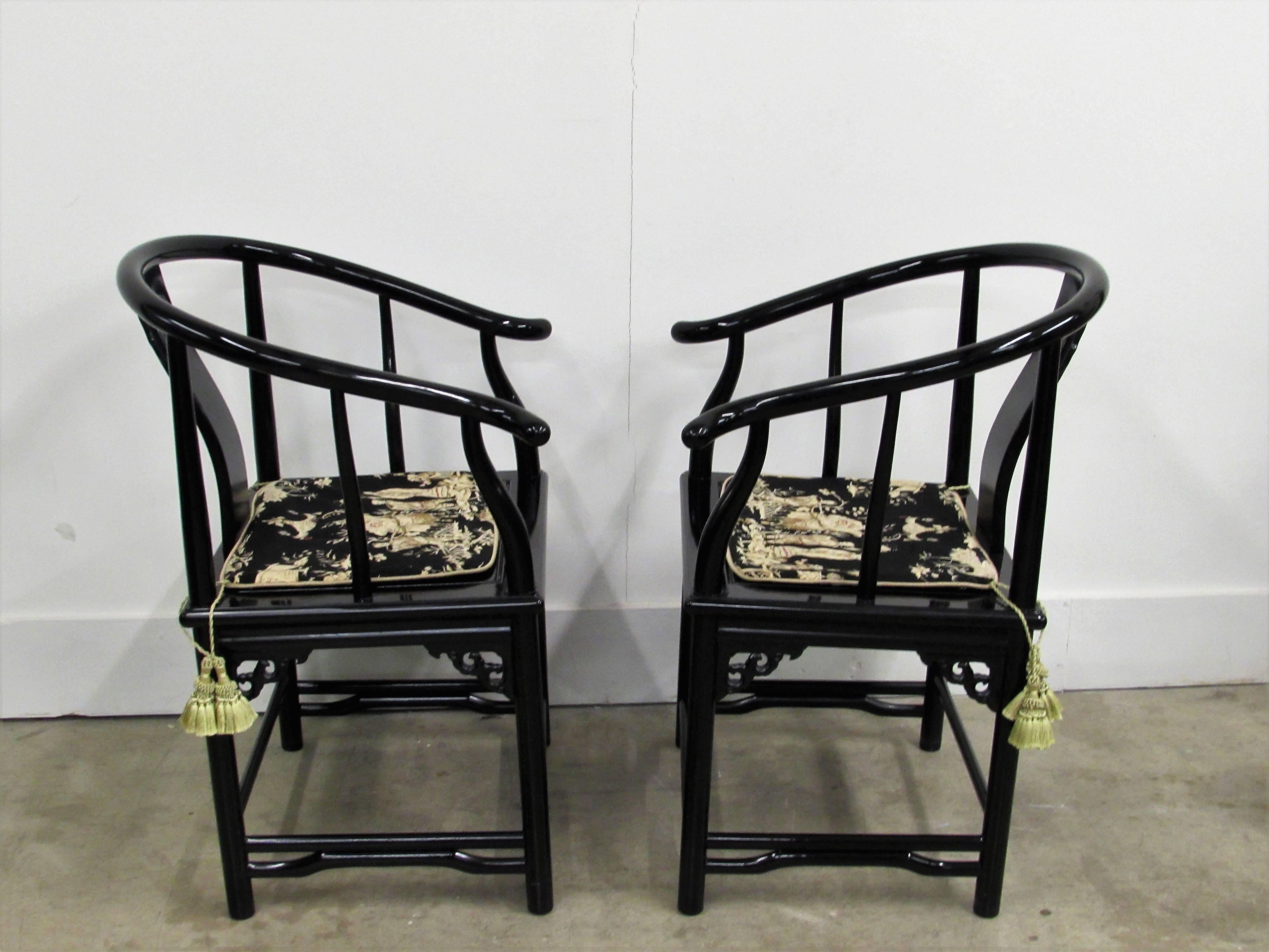 Black Lacquer Asian Horseshoe Arm Chairs with slat back and chinoiserie symbol, seat cushion is Asian hand-painted toile in black &cream fabric with gold tassels. Hand-carved corners in elmwood under lacquer.
 