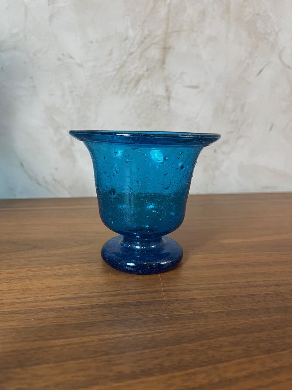 Vaso o bicchiere in vetro soffiato in stile Biot. Il suo colore blu intenso, con sottili variazioni di tono che catturano splendidamente la luce, insieme alle sue caratteristiche bolle, gli conferiscono un fascino unico e senza tempo.