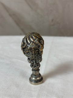 Timbre en bronze du XVIIIe siècle portant le monogramme « AD » et orné de putti et de motifs floraux