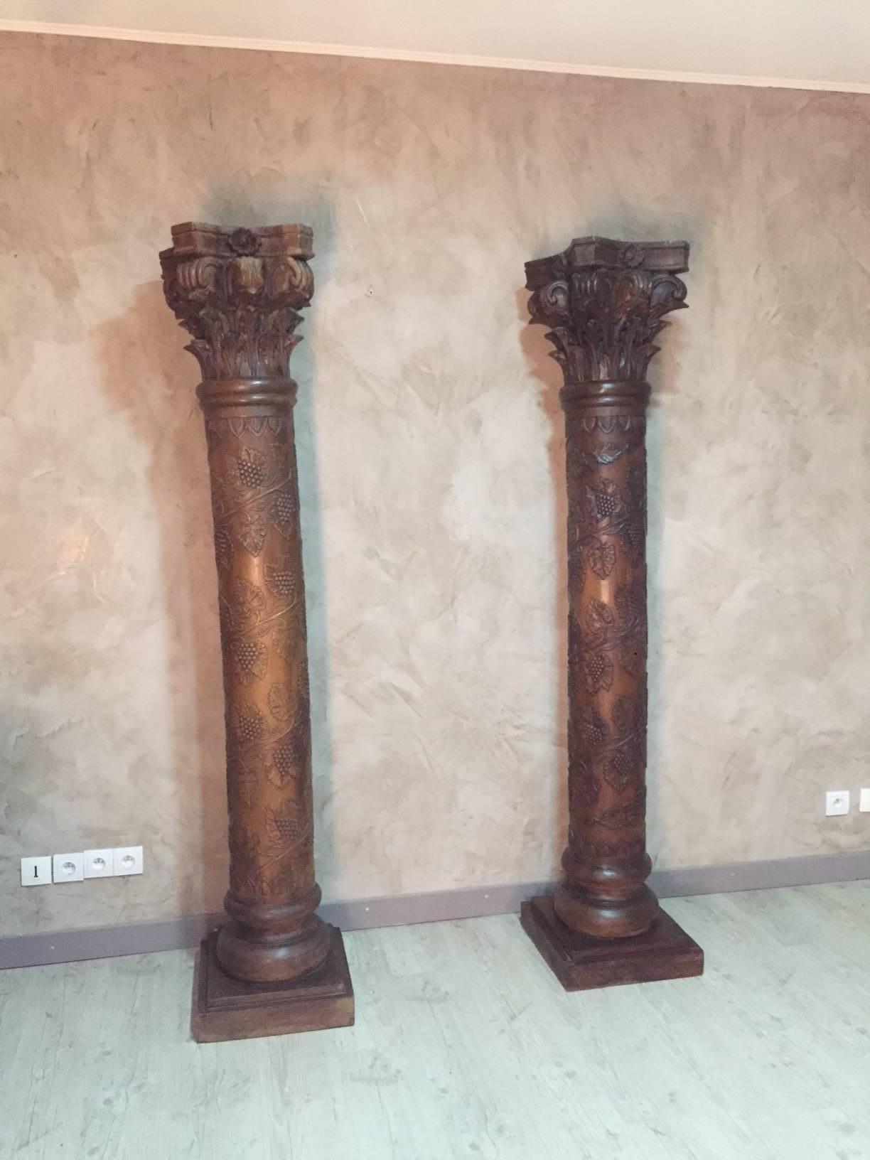 Very nice pair of carved wood column with wine grapes drawing and vine leaves. It is topped with a very beautiful sculpture quality.
