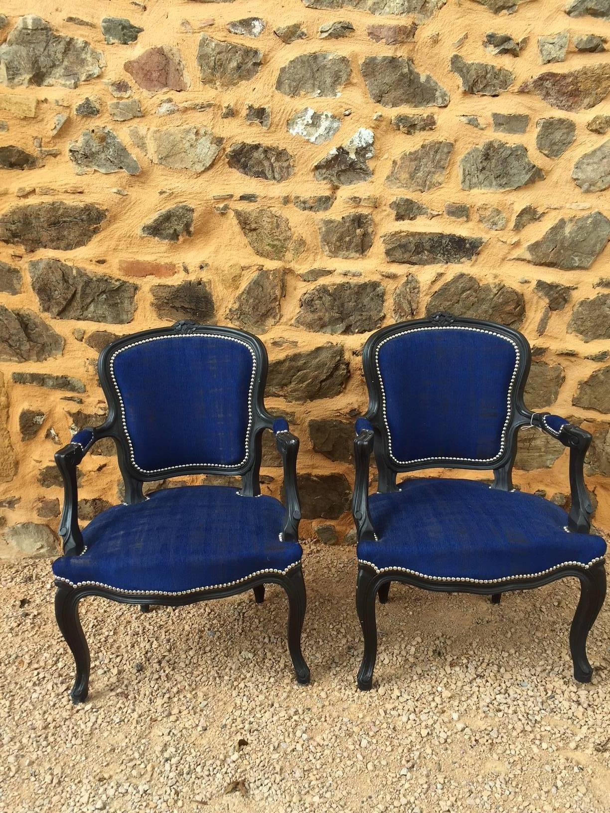 Pair of Louis XV style Cabriolet chairs completely redone with a nice blue heather fabric. The wood has been painted in mat black. To give a contemporary look we made the finishes with silver nails.
The repair of this pair of Cabriolet has been