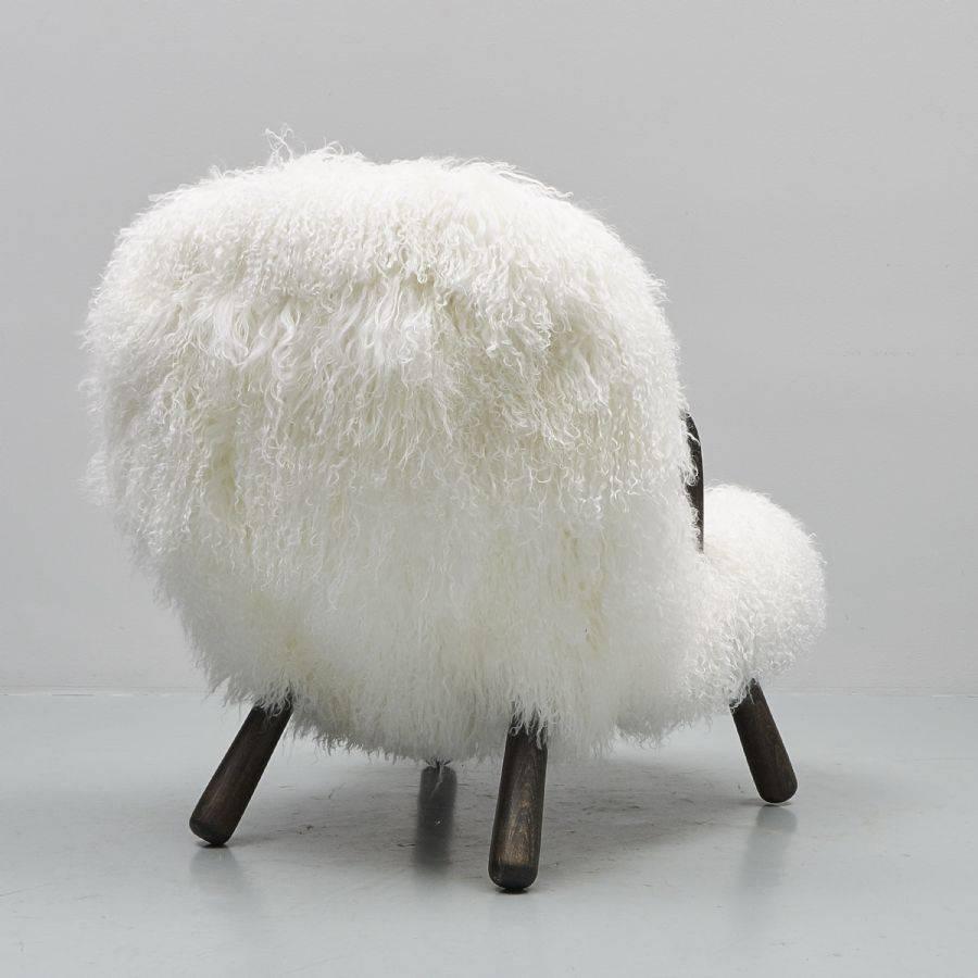 Iconic clam chair designed by the famous designer Philip Arctander in Denmark, circa 1940. The model is made out of wood on arms and legs and long hair sheepskin really rare model on this configuration.