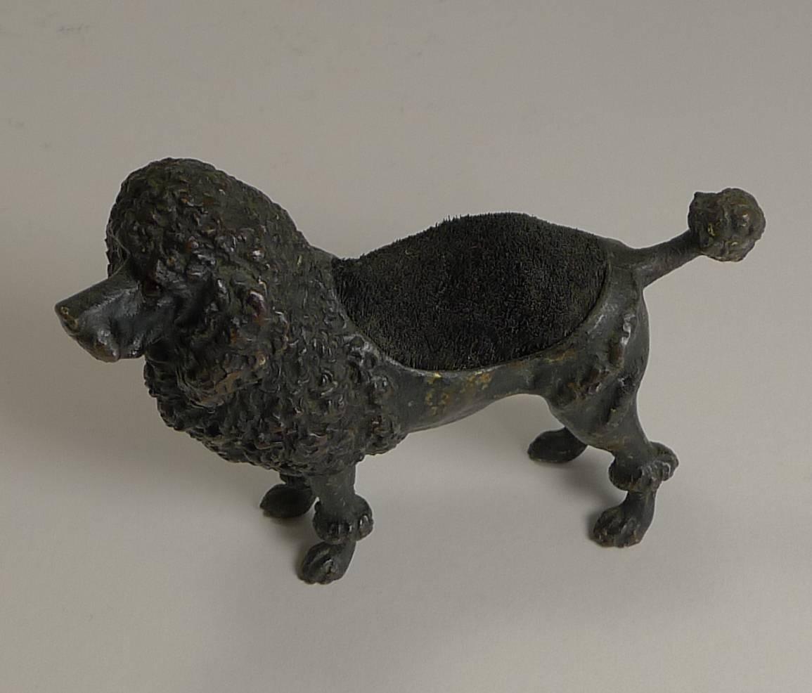 A charming novelty cast bronze pen or nib wipe in the form of a poodle, beautifully executed and retaining two tiny glass eyes.

The back is where the original natural bristle wipe sits for the excess ink to be wiped from traditional pen