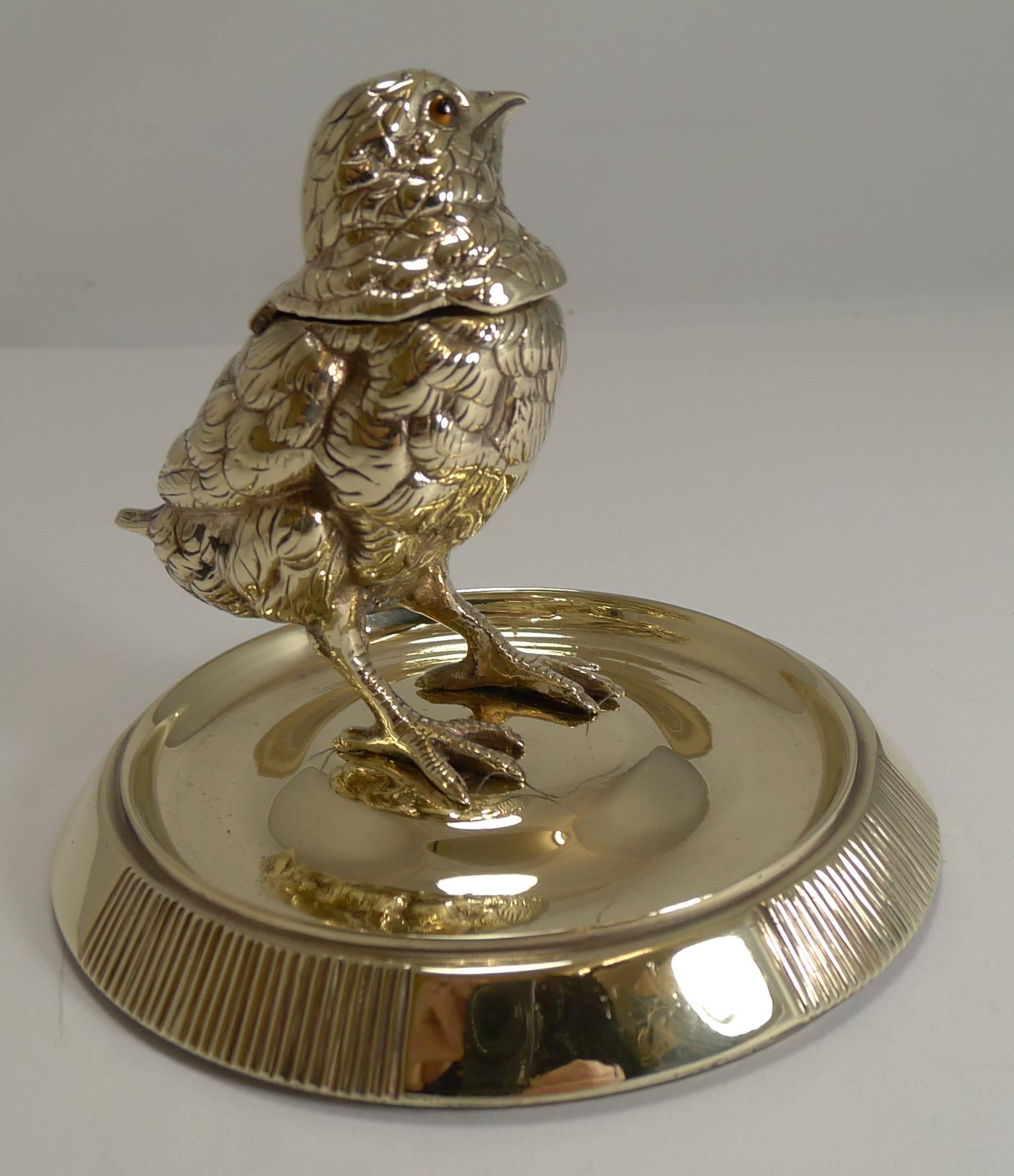 A truly adorable desk-top accessory, a combined inkwell and match striker.

Made from solid cast brass, the Chick is beautifully executed with lovely detail and retaining his two original glass eyes. The hinged head lifts to reveal a removable ink