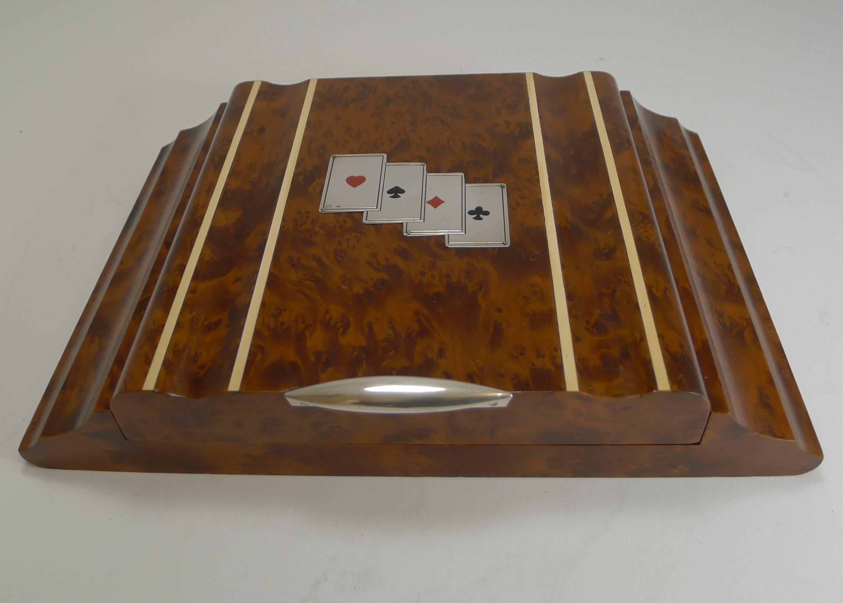 A truly smart Italian shaped Art Deco games box made from highly figured Amboyna, one of the most expensive and highly sought-after burls in the world.

The box is mounted with a suite of playing cards made from 800 silver and signed by the Florence