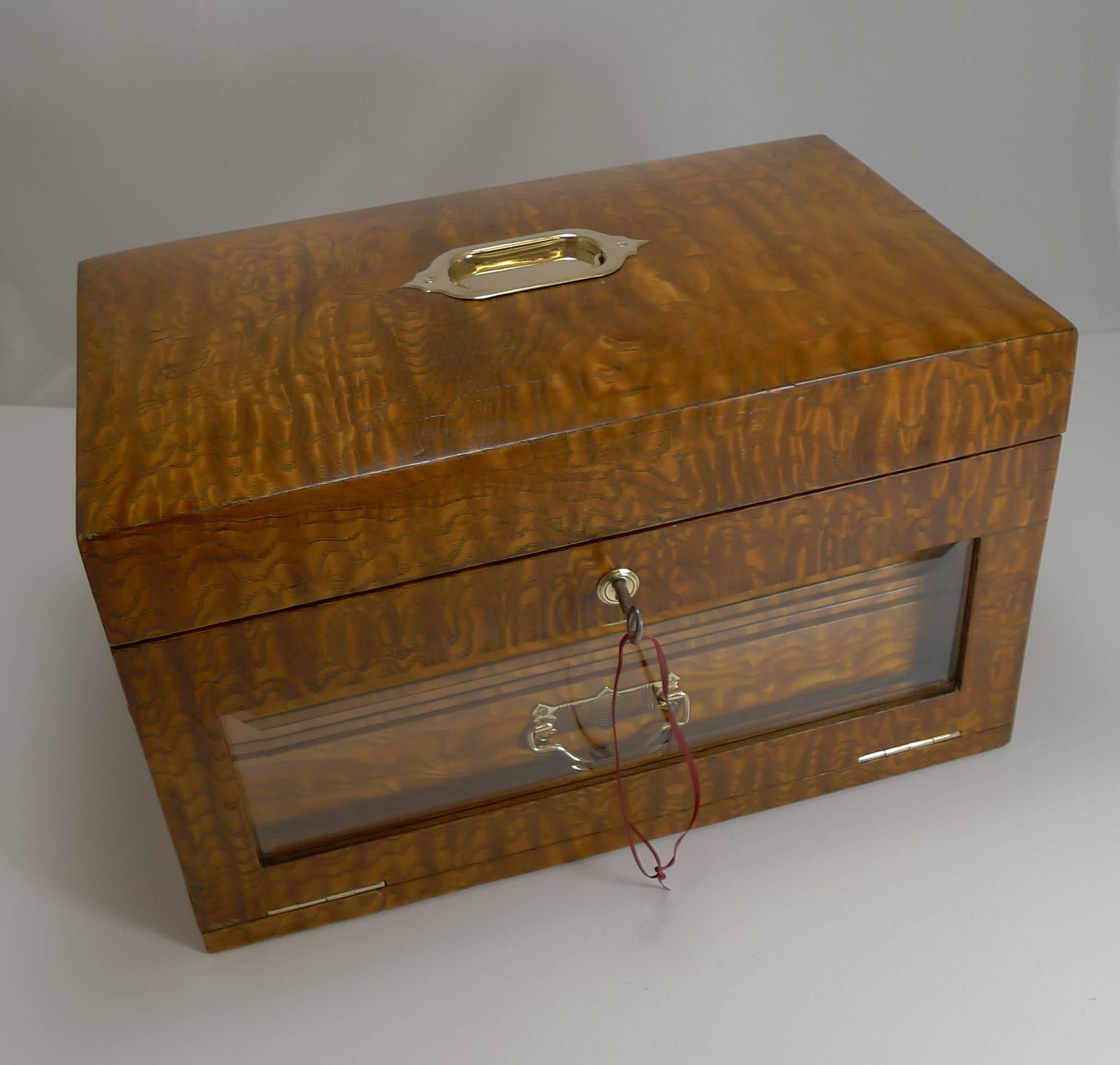 A beautiful late Victorian jewellery box and a grand, very usable size.

Made from one of my favourite timbers, Burr Ash with it's golden wavy figuring. The top is inset with a flush polished brass handle. The front has a mounted brass escutcheon