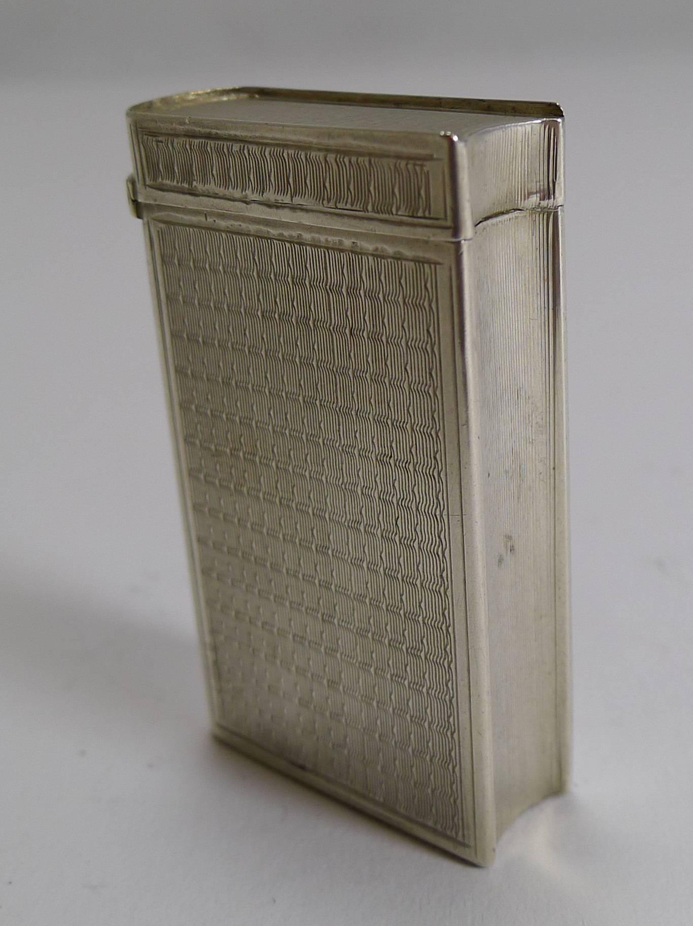 A charming little vesta in the form of a miniature book with fine quality engine turned decoration and a vacant cartouche to the front. The strike is to be found on the underside of the book.

The hinged lid is sprung and in perfect working order.