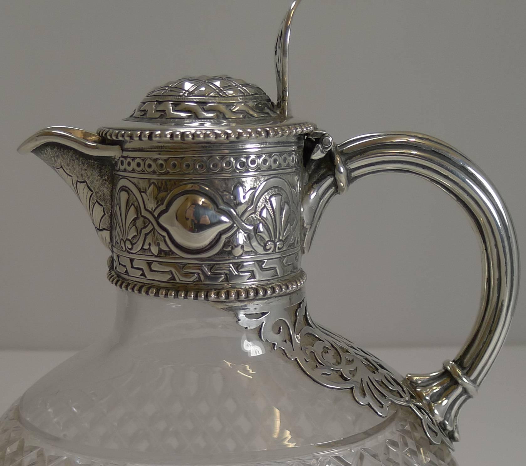 A magnificent and unusual Victorian claret or wine jug or pitcher, made from English cut crystal, deeply cut and without damage.

The fittings are made from English sterling silver including the fabulous pierced or reticulated decoration running