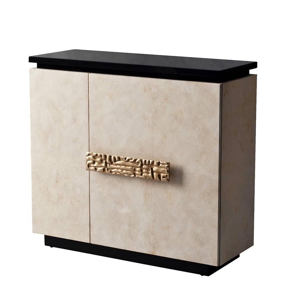 The Andre cabinet or sideboard by DeMuro Das is sheathed in our matte Ivory Carta, a paper-based veneer that is reminiscent of parchment in its appearance and application. The glossy black top is veneered in Koto, an unusual African hardwood. The