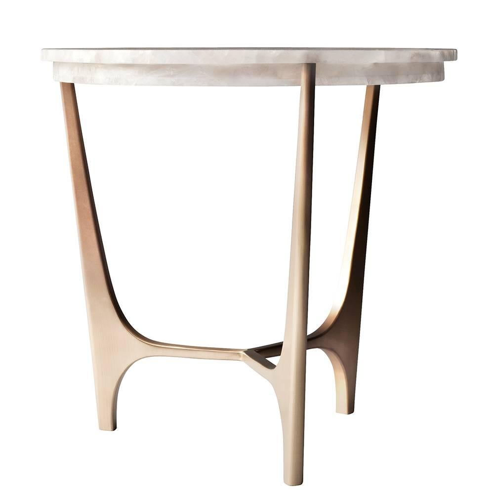 The Athena side or end table by DeMuro Das has a circular top in White Quartz supported by a sculptural, hand-cast solid Bronze base. The White Quartz has a semi-translucent quality that highlights the subtle variations of color within the stone.