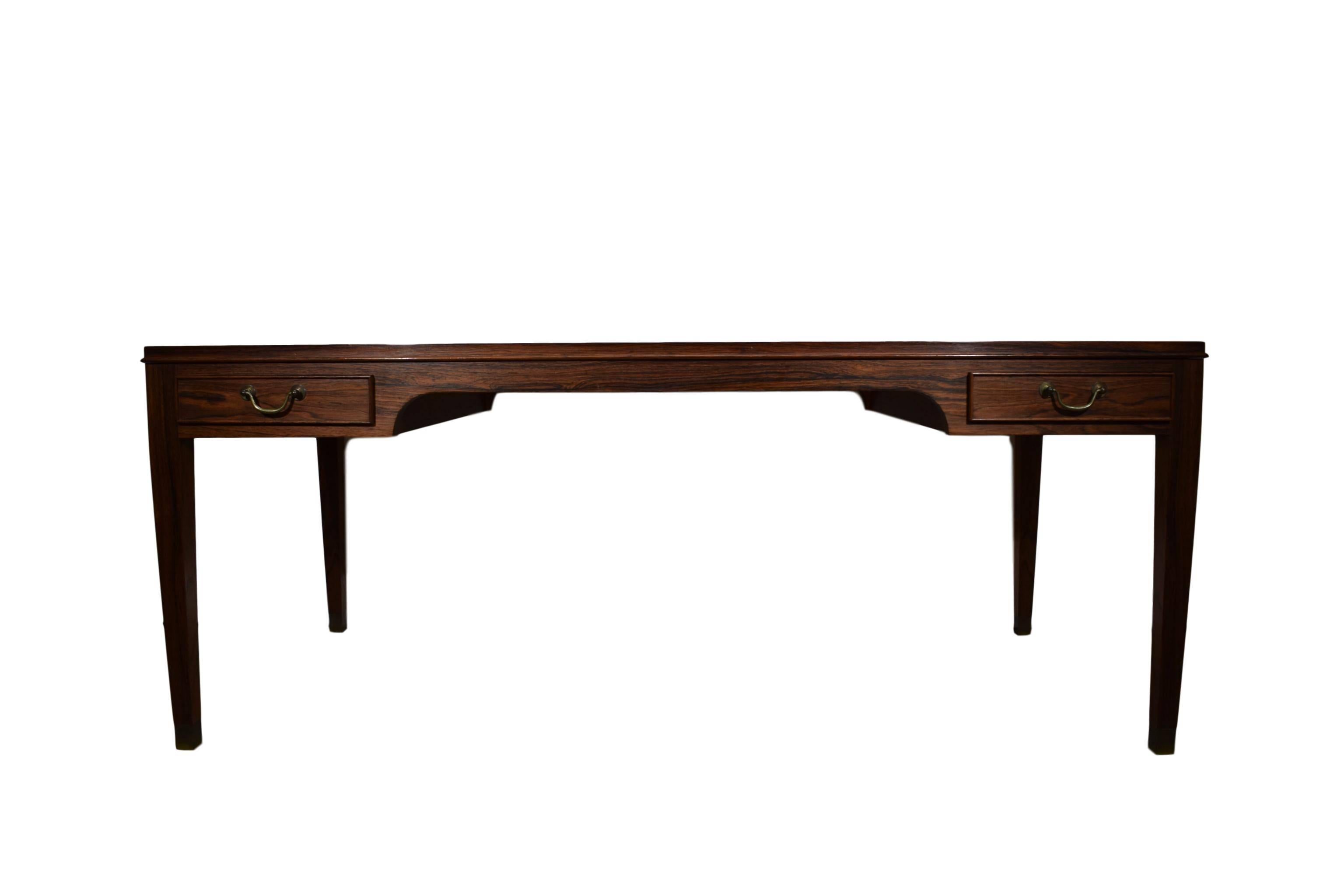 A Danish midcentury rosewood coffee table by Frits Henningsen. Rosewood veneer and solid rosewood legs. Four drawers with brass handles. Tapered legs with brass shoes.

 