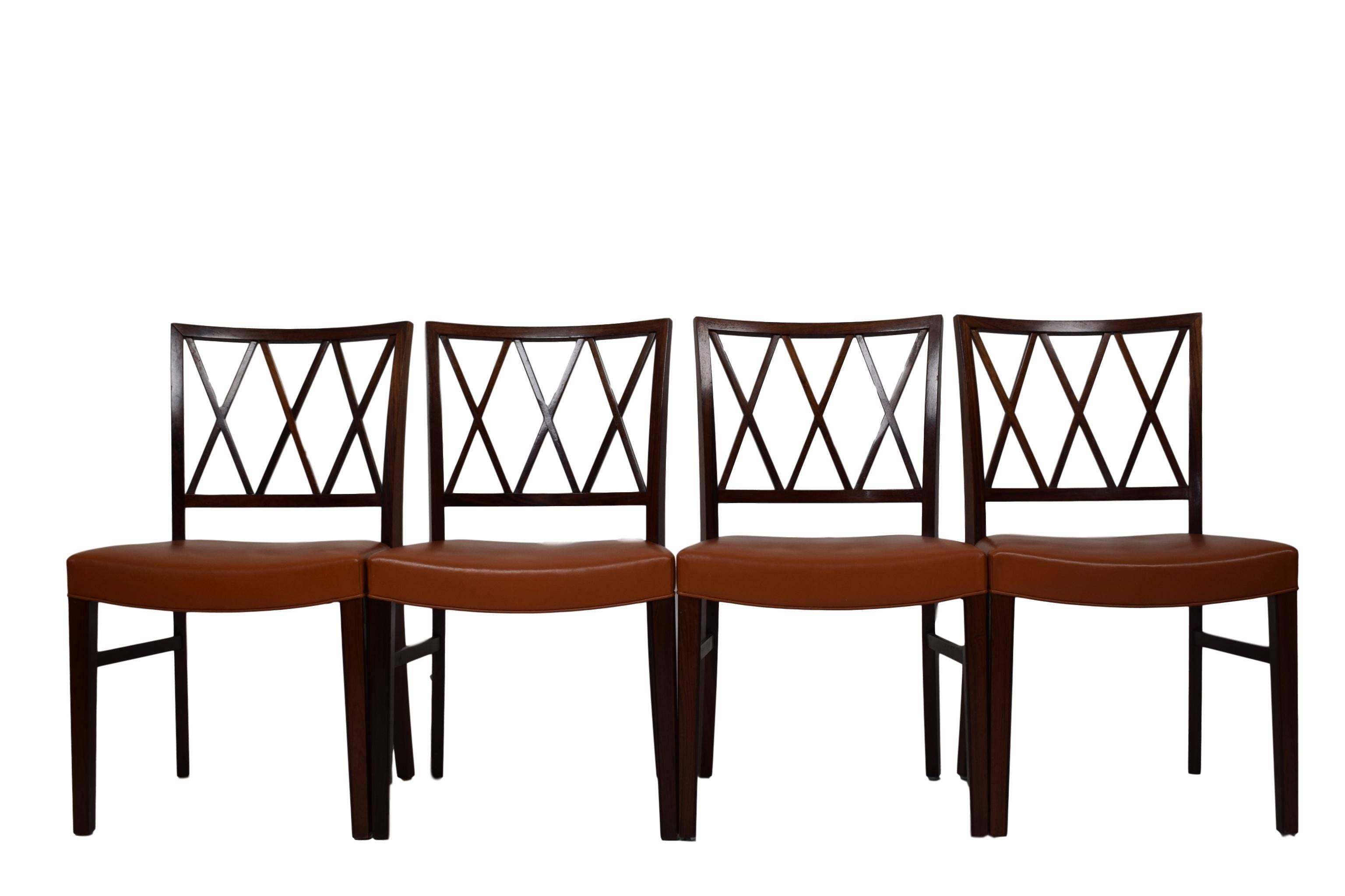 A set of four Danish midcentury rosewood dining chairs by Ole Wanscher (1903-1985). Produced by Slagelse Møbelværk. Upholstered with cognac brown leather.
 