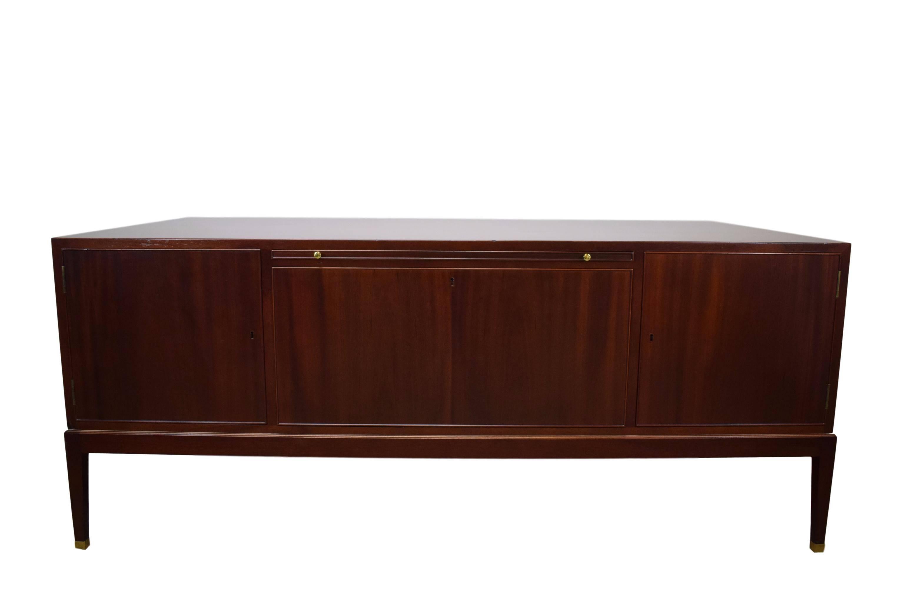 A Danish midcentury desk in mahogany. With ten drawers on the front and three cabinets plus on pull-out tablet on the rear. Bras handles and shoes. Produced on Philips Fabrik. Plate with the text 