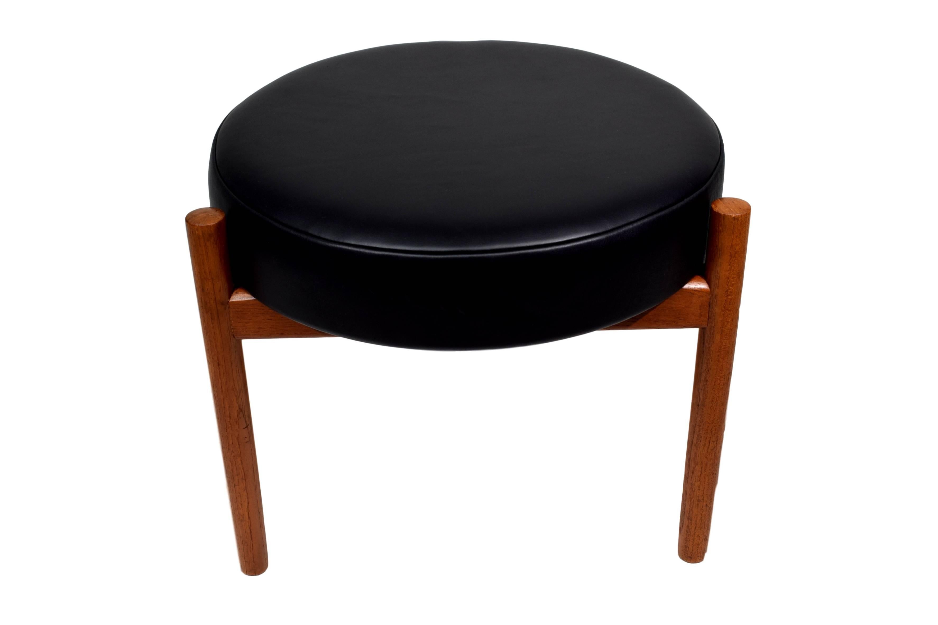 A Danish midcentury teak ottoman by Hugo Frandsen. Produced by Spøttrup. The ottoman is newly upholstered with smooth, black, high-end elegance aniline leather with natural markings from Sørensen leather.



   