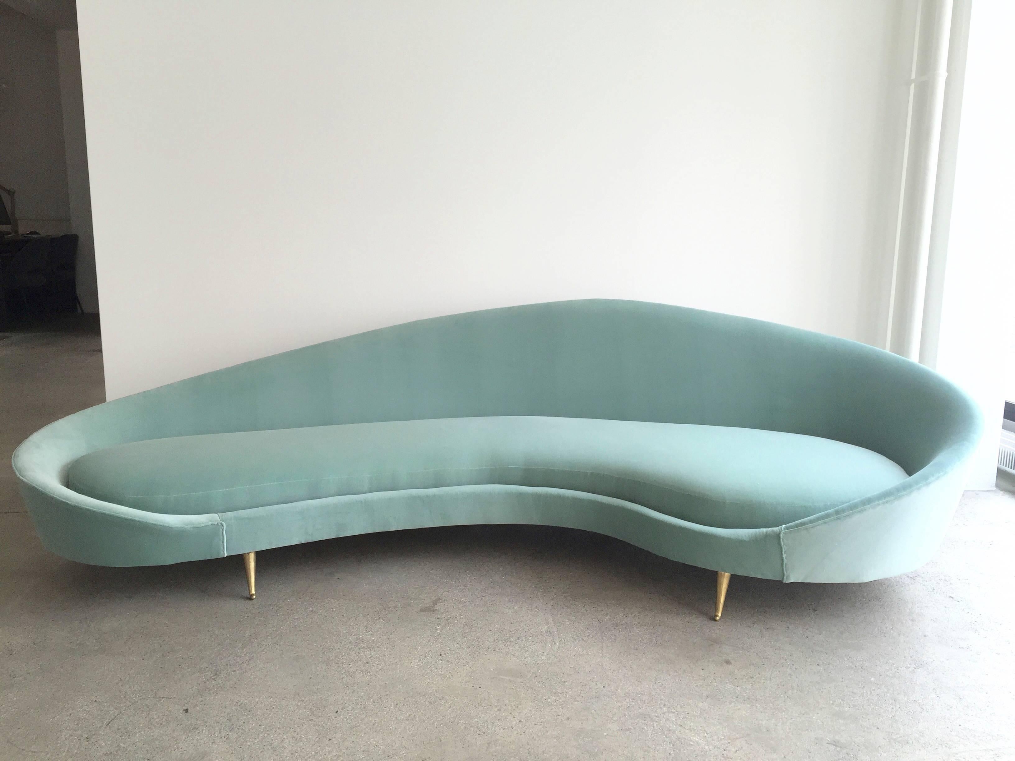 In the style of Federico Munari vintage curved sofa in velvet and brass feet from 1960s.