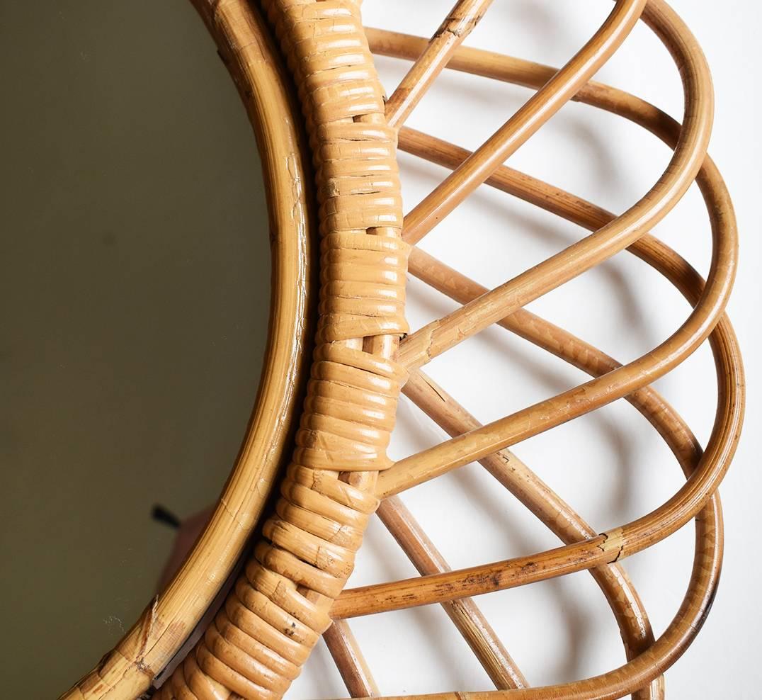 A flower burst or sunburst oval mirror handcrafted with rattan cane and wicker. A natural and fresh accent for any space with a taste of the Mediterranean Coast. These kind of mirrors were typical in Italy 1950s-1970s. And this one is signed by