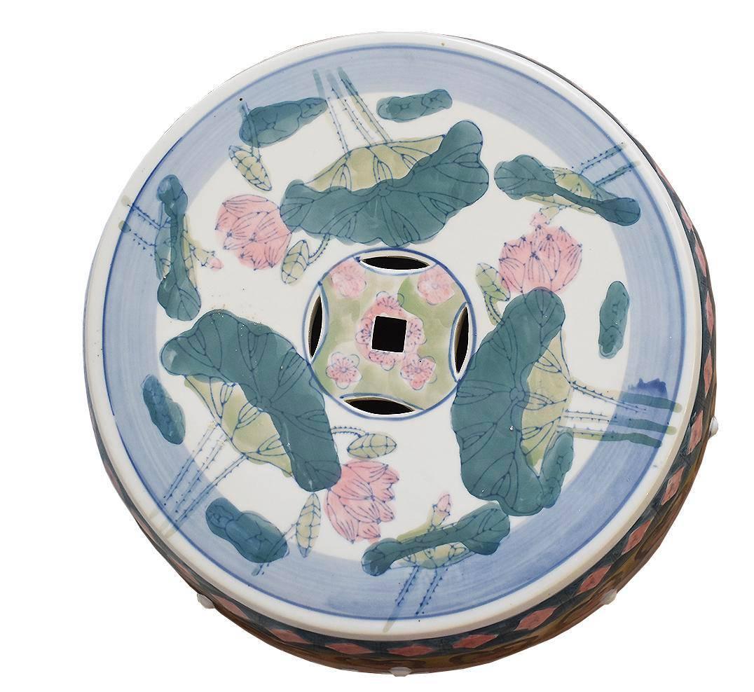 Beautiful porcelain garden stool featuring cut-out designs, raised bosses and a glossy finish. Intricate Chinese hand-painted lotus flowers, crane and dragon fly pattern. Small hairline crack on the side but in otherwise great condition. Would be