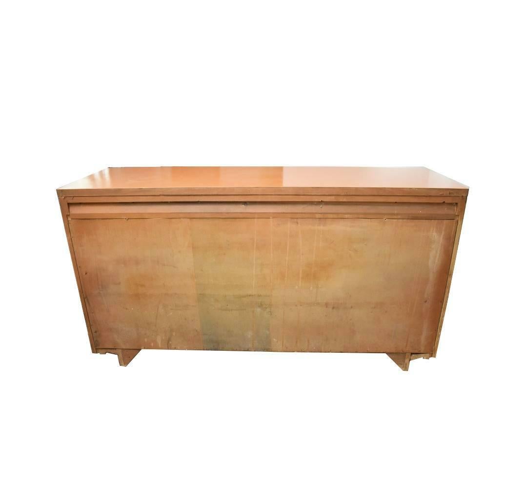 This is a bright orange lacquered, Mid-Century Modern credenza or dresser. Nine drawers feature inlaid brass detail and turquoise drawer pulls. Original maker unknown, but condition is fantastic. All wood. Paint is high gloss and very shiny. This