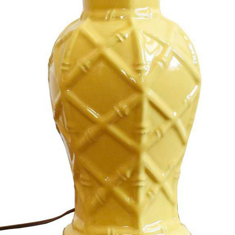 Sunny yellow glazed Hollywood Regency or Palm Regency chinoiserie faux bamboo table lamp. This Mid-Century Modern era lamp features a ceramic ginger jar shape ceramic body with detailed raised bamboo latticework relief. Original wiring in working