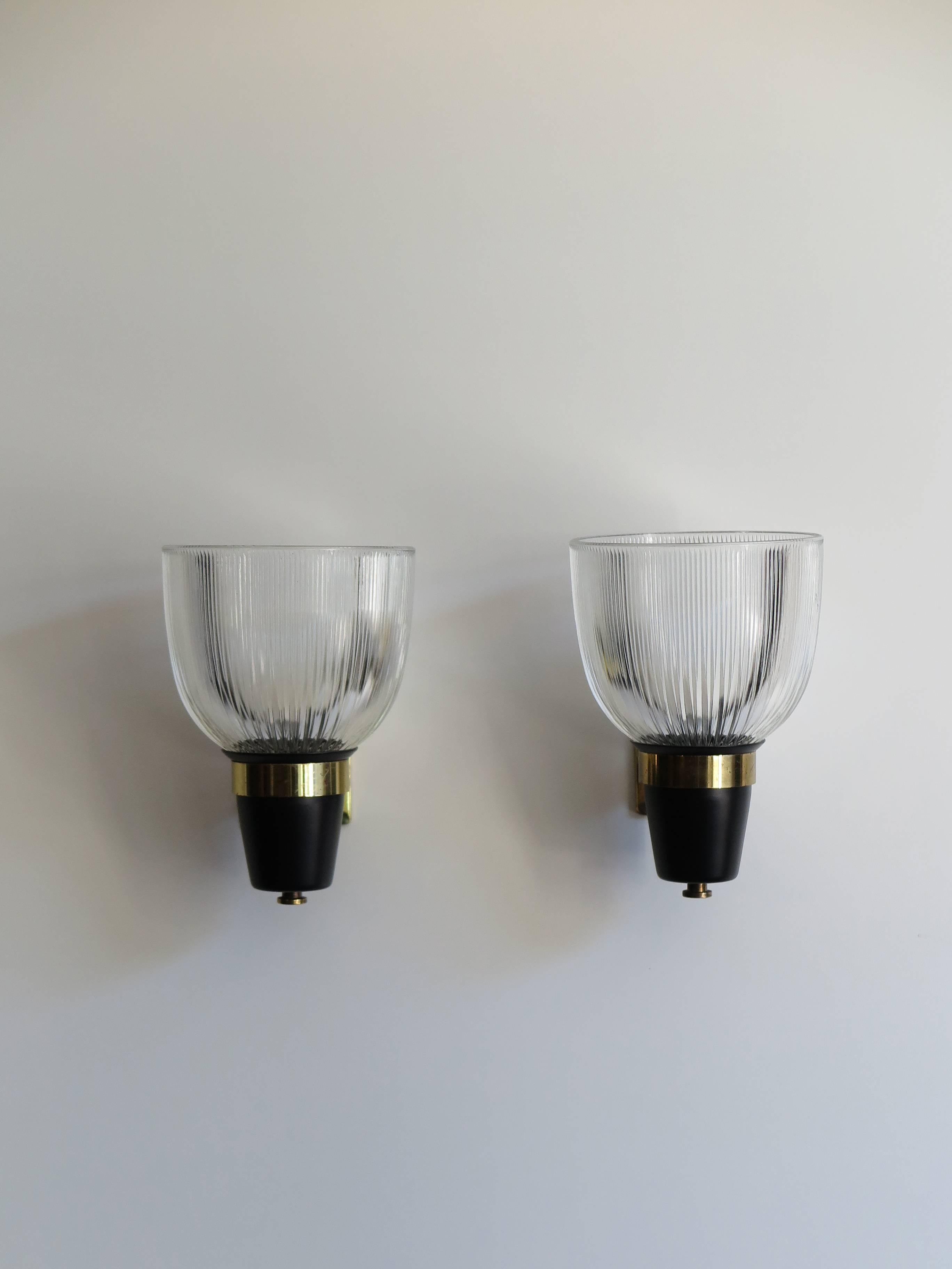 Set of four Italian Mid-Century Modern sconces or wall lamps designed by Ignazio Gardella (attributed) with pressed glass, painted metal and brass structure, circa 1950s.
Glass diameter 16 cm.