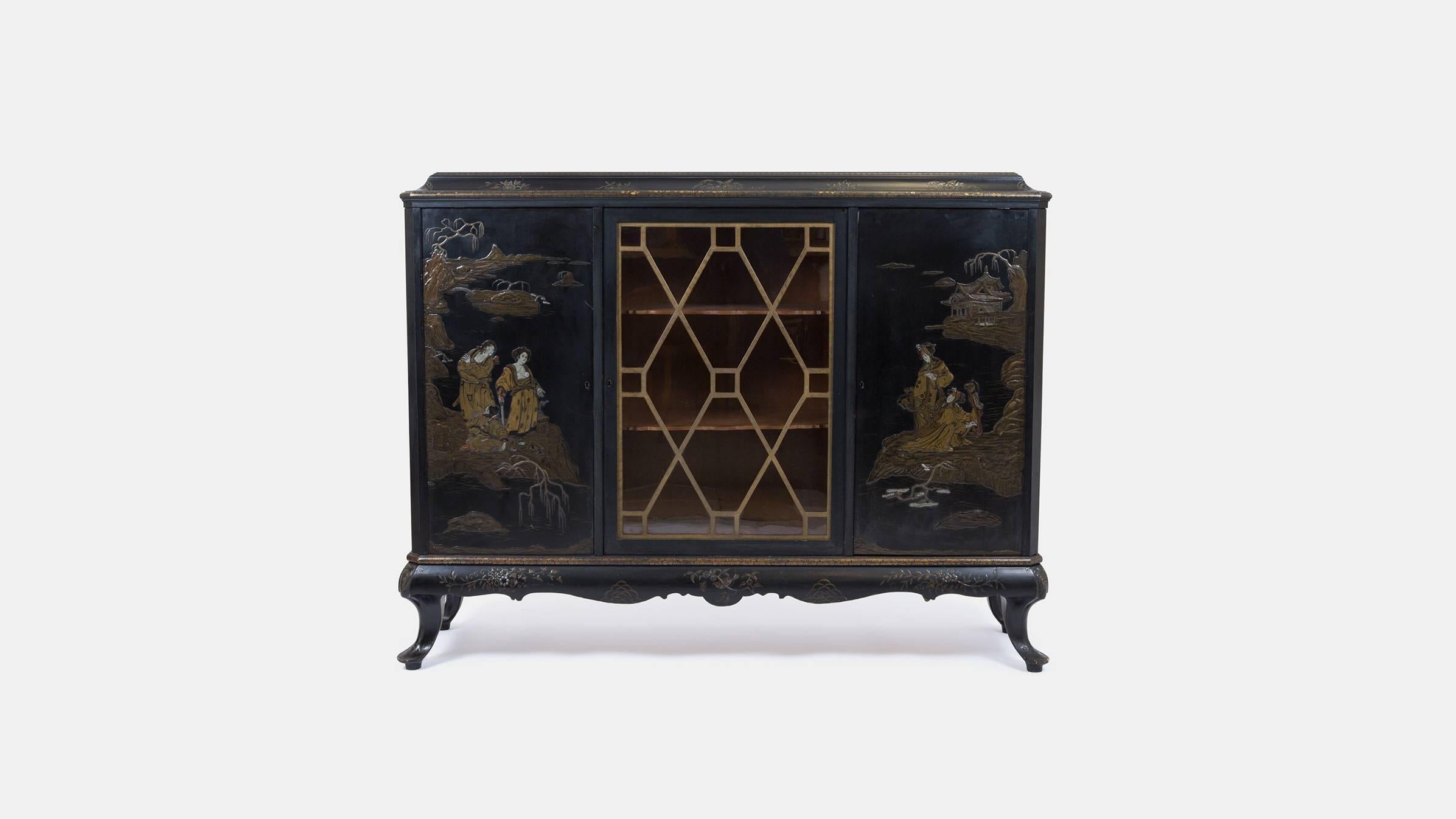 A stunning early 20th century French ebonized and chinoiserie lacquer side cabinet by Maison Jansen. The substantial cabinet has three cupboards, each with three shelves. Stamped Jansen (top right door, see image).

The Paris based design firm was