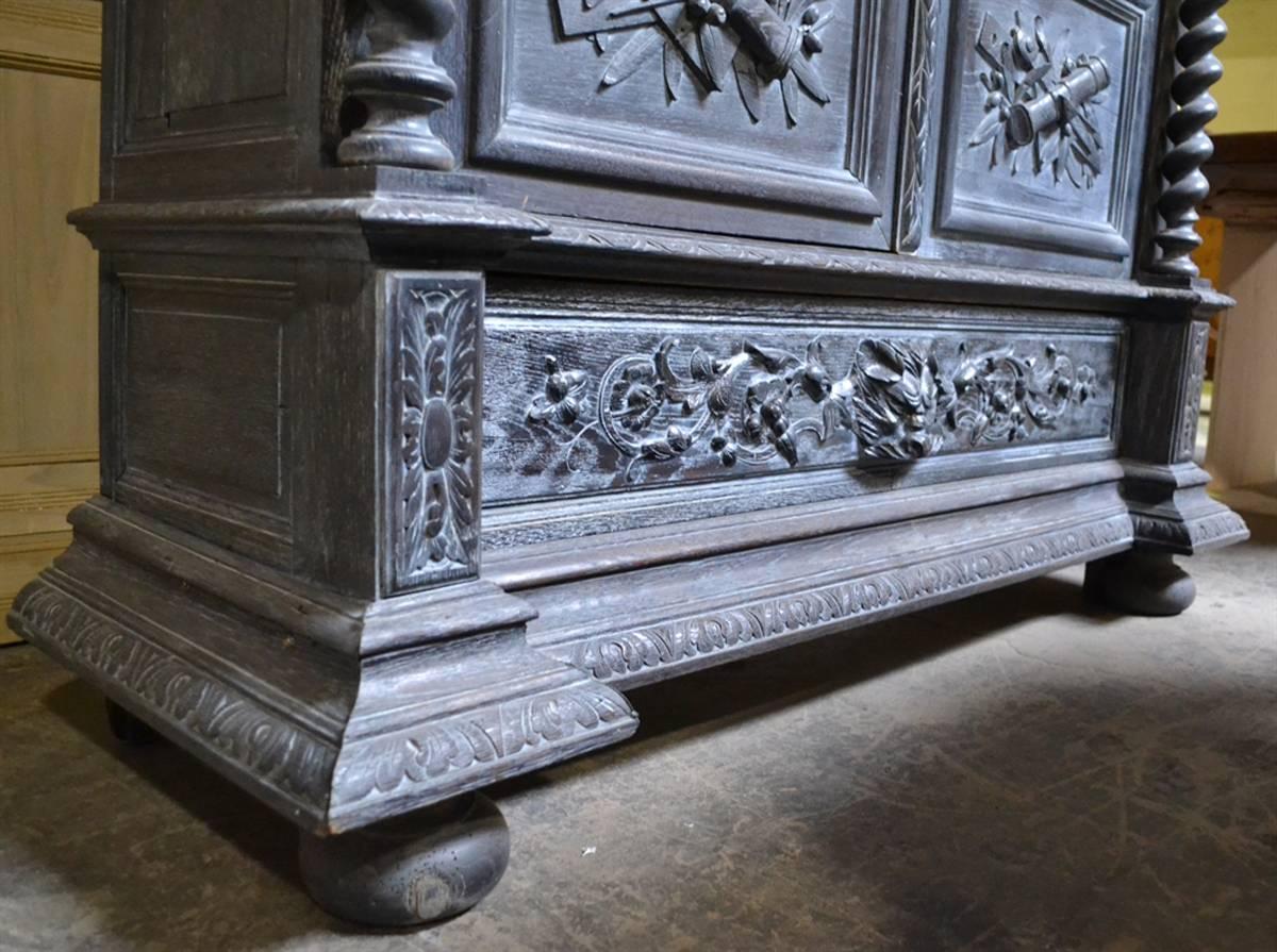 This antique French cabinet, from the mid-1800s, was purchased in Paris. It's of a style often used in hunting lodges and is beautifully carved in oak, with a lower drawer above the feet. We've applied a cerused ebonized finish to the cabinet and