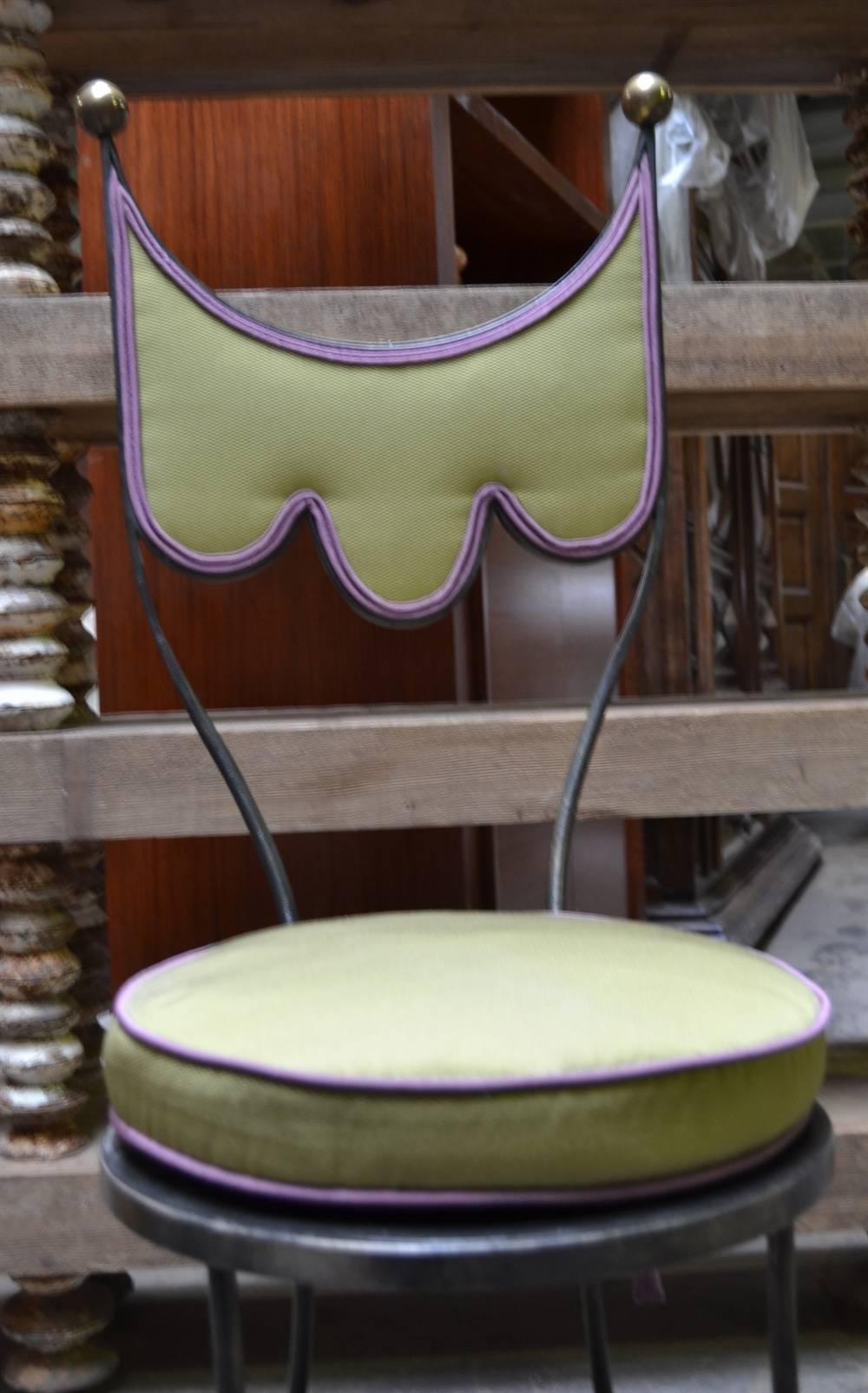 These playful 1960's iron chairs are accented by round brass finials. They are from the personal residence of Mr. Gruen, and we covered them in a lime green fabric trimmed in purple.