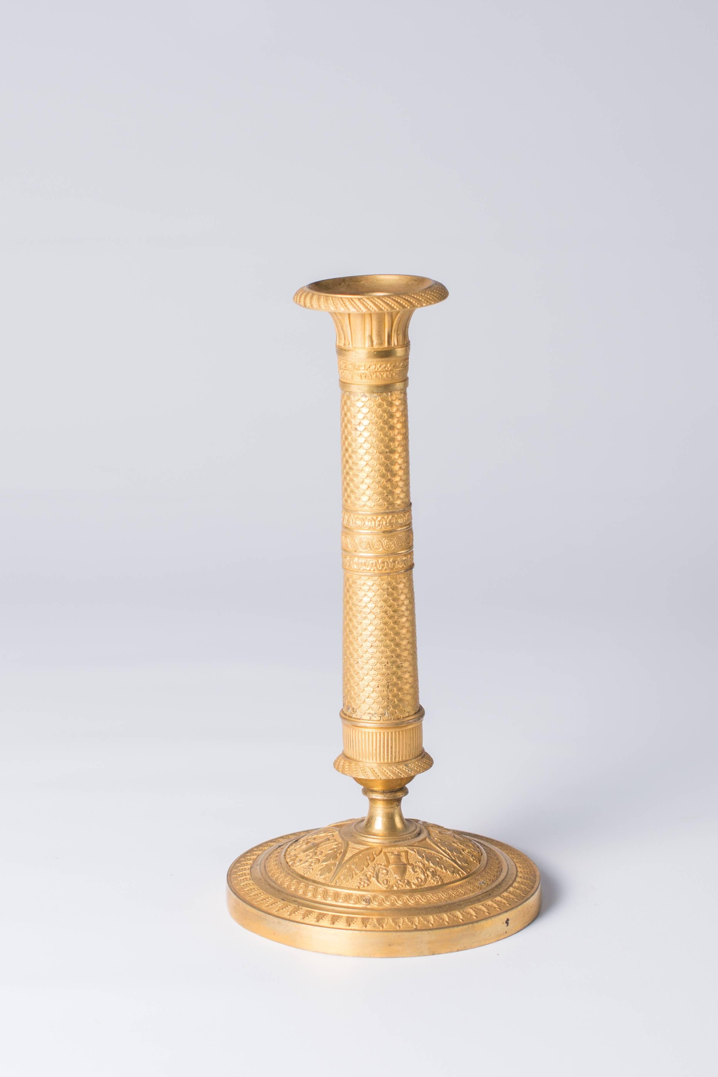 This pair of candlesticks are in gilt bronze. Each on a circular low domed base with a tapering stem and spreading candleholder with guilloché and stylized foliate cast decoration.
France, epoque Empire, 1810-1820.
This pair will lighten your
