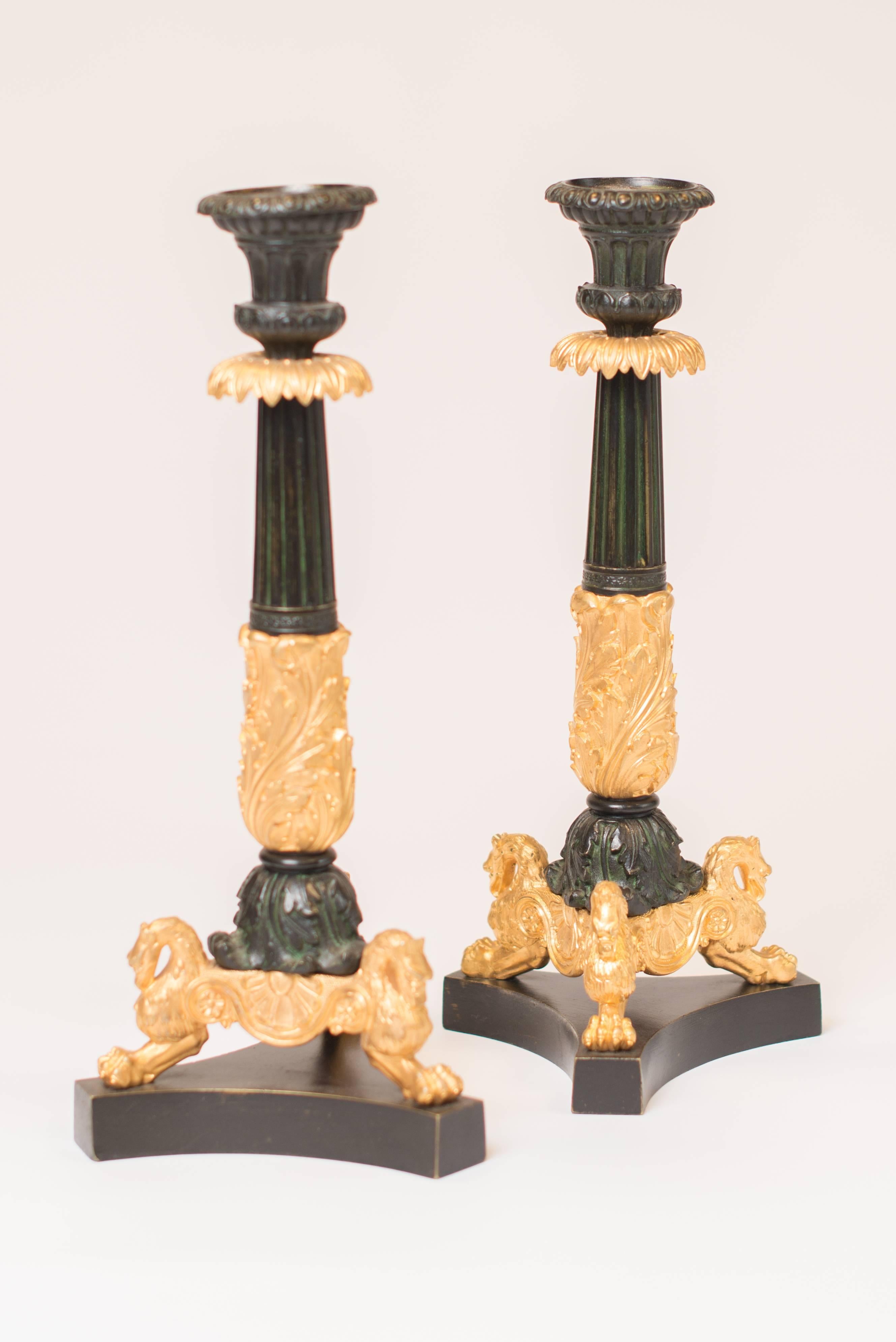 This pair of French Louis Philippe gilt bronze and patinated candlesticks do have finely finished decoration. Made in France, circa 1850
Each candlestick with a plain triangular shaped plinth, three gilt claw feet with griffin finials, foliate