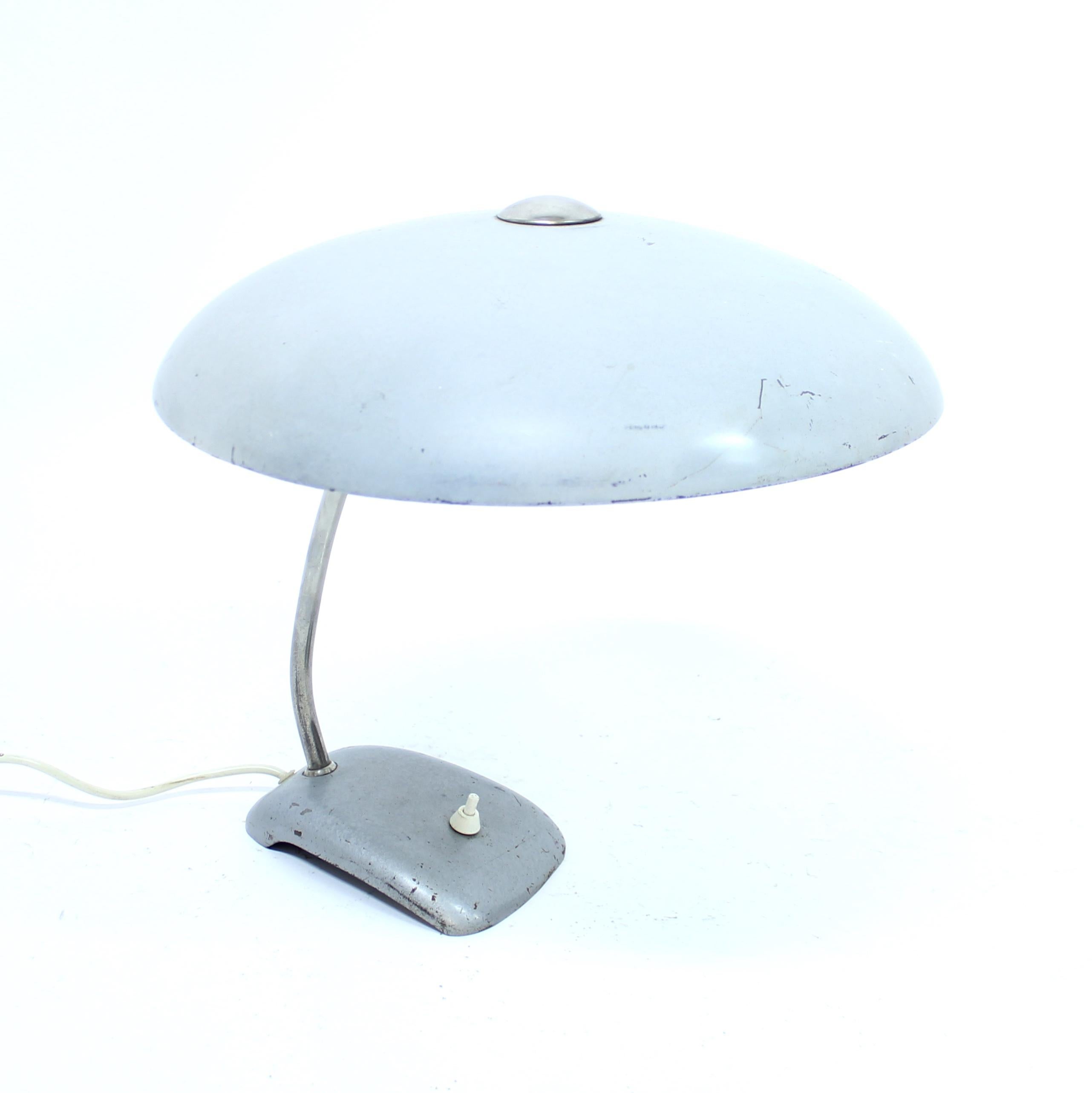 Industrial table lamp from the 1930s with round sheet metal shade one a chromed stem mounted to a metal base. Attributed to designer Christian Dell for Kaiser Idell. New plug. Decent condition with normal ware consistent with age and use including